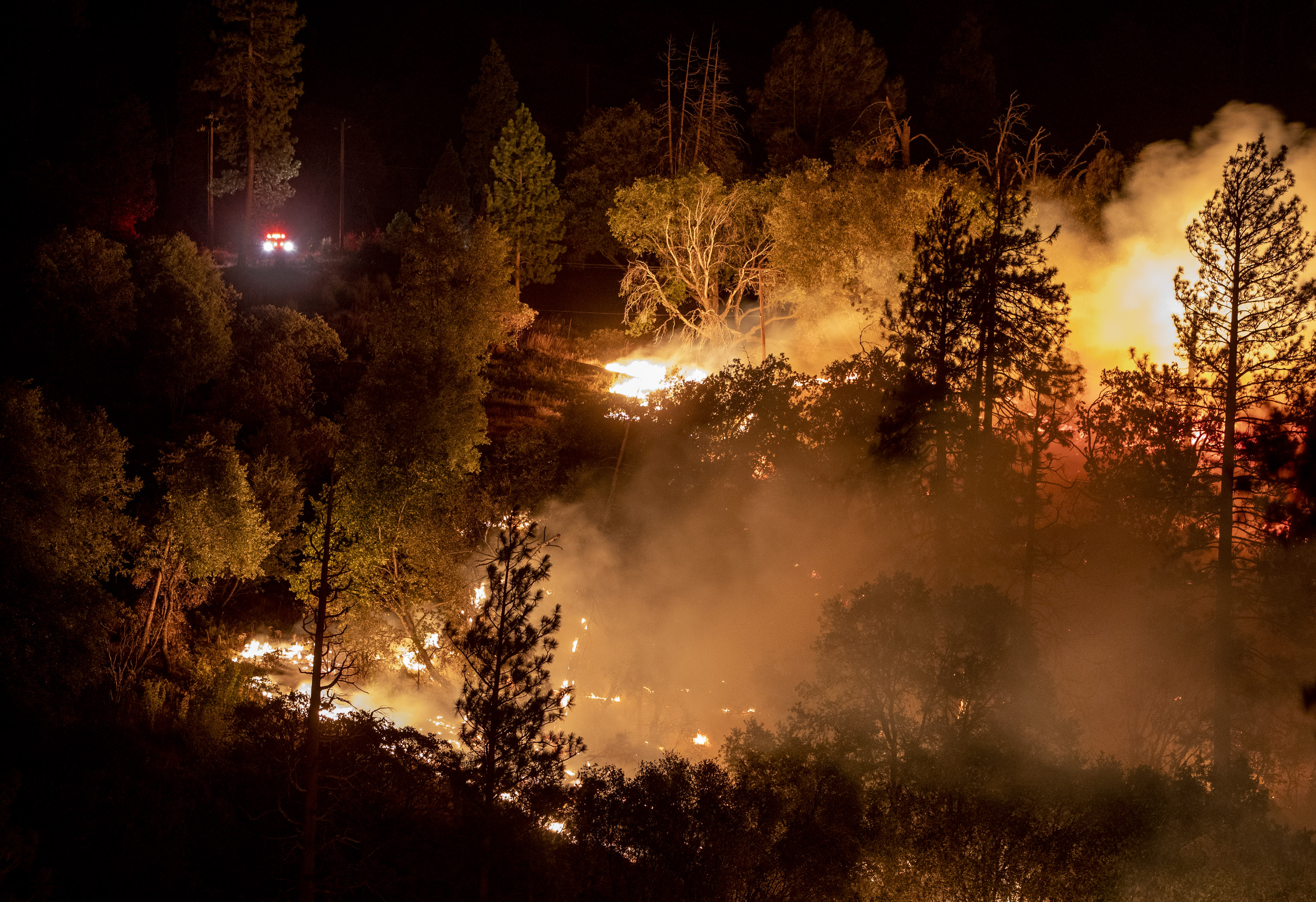 MARIPOSA, CALIFORNIA - JULY 23: Firefighters park above the Oak Fire as they monitor the blaze burning near Yosemite National Park in Mariposa, Calif., early Saturday morning July 23, 2022. (Karl Mondon/Bay Area News Group)