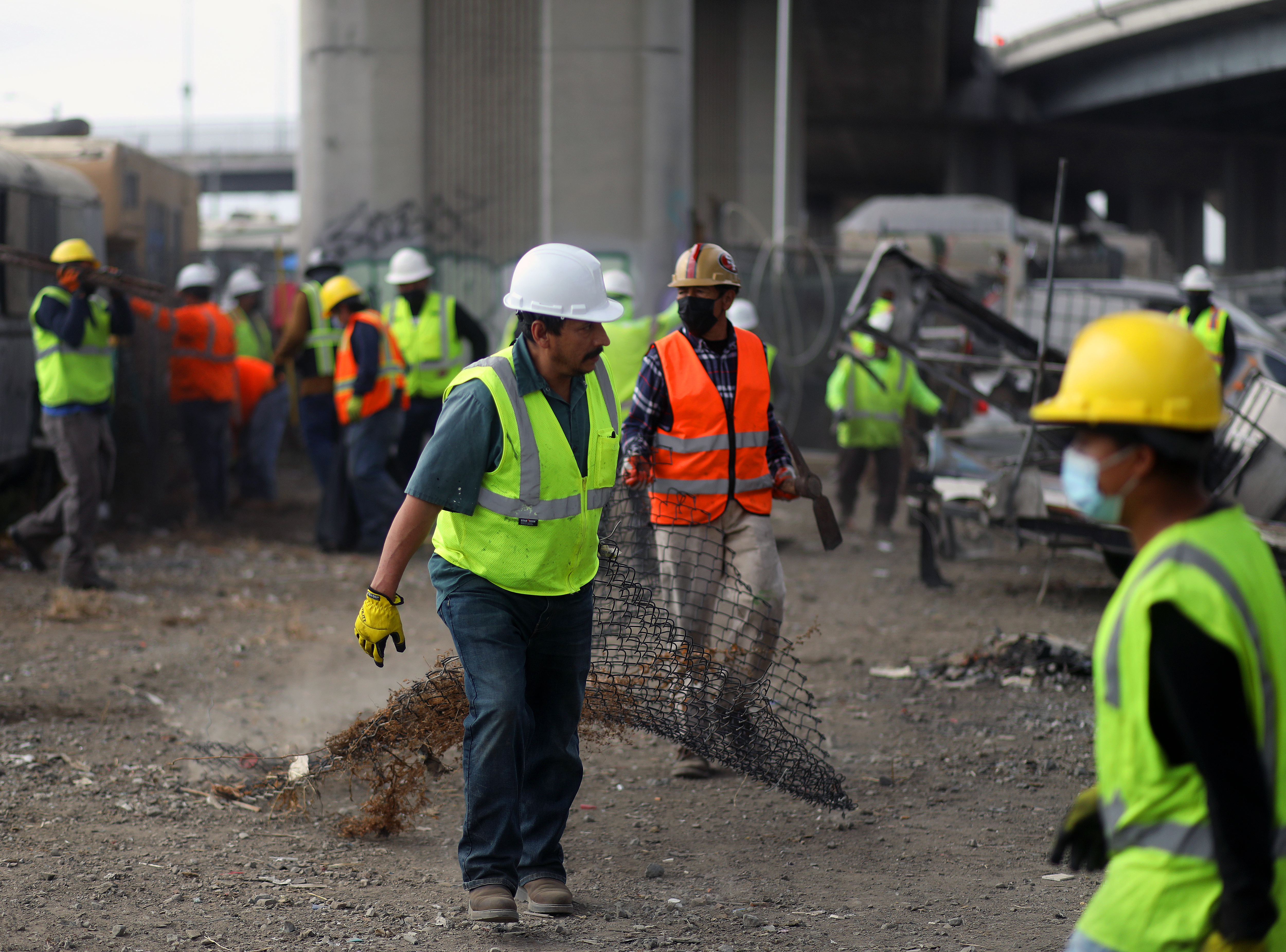 OAKLAND, CA - SEPTEMBER 26: Workers remove debris from the Wood Street homeless encampment on Monday, Sept. 26, 2022, in Oakland, Calif. Caltrans is overseeing the cleanup of its property along Wood Street. (Aric Crabb/Bay Area News Group)