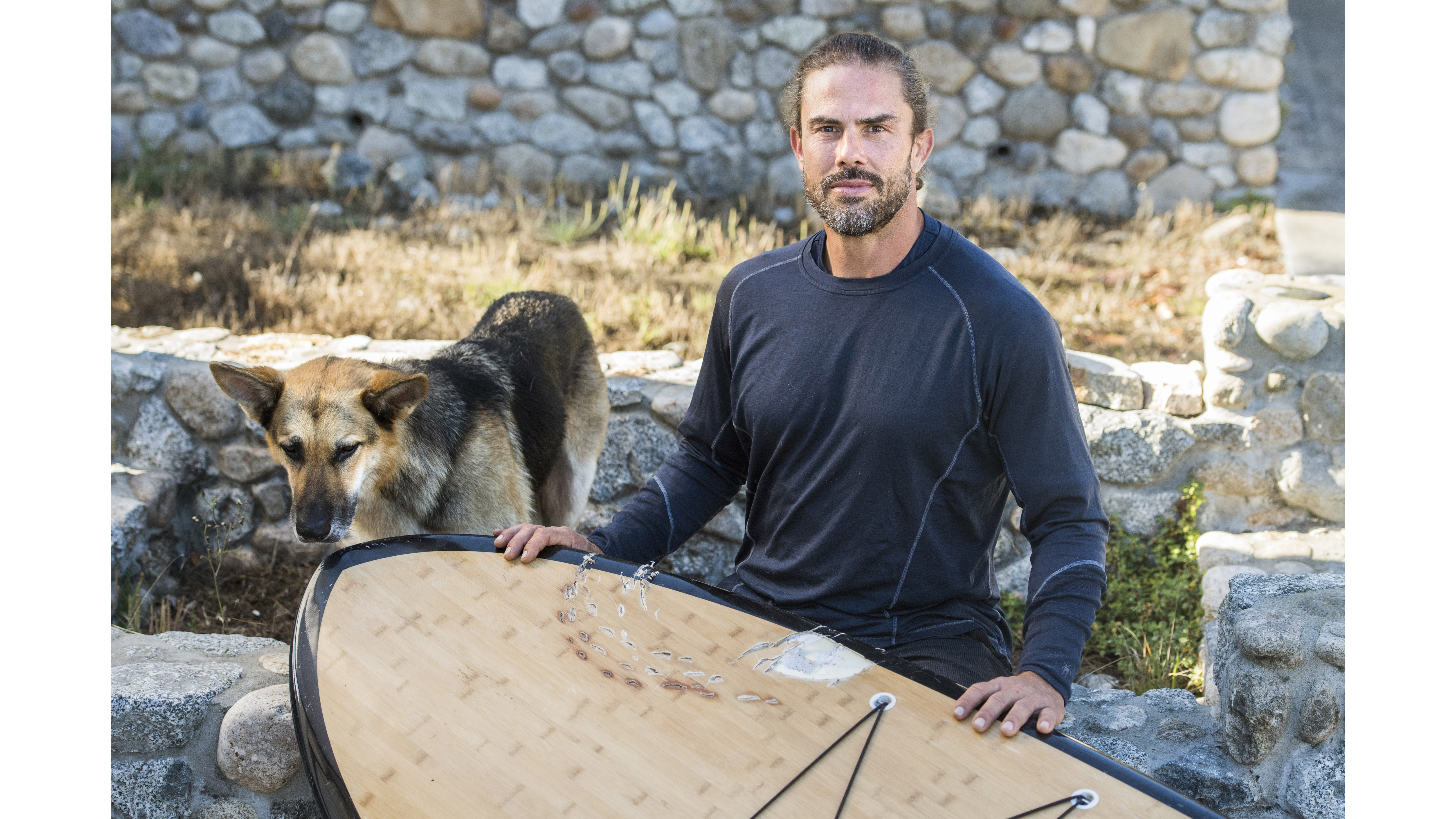 PACIFIC GROVE, CA - SEPTEMBER 23: David Stickler, of Pacific Grove, and his dog Brutus, are photographed in Pacific Grove on Sunday, Oct. 2, 2022, with the paddle board both were on during a recent shark attack at Lovers Point. (Doug Duran/Bay Area News Group)