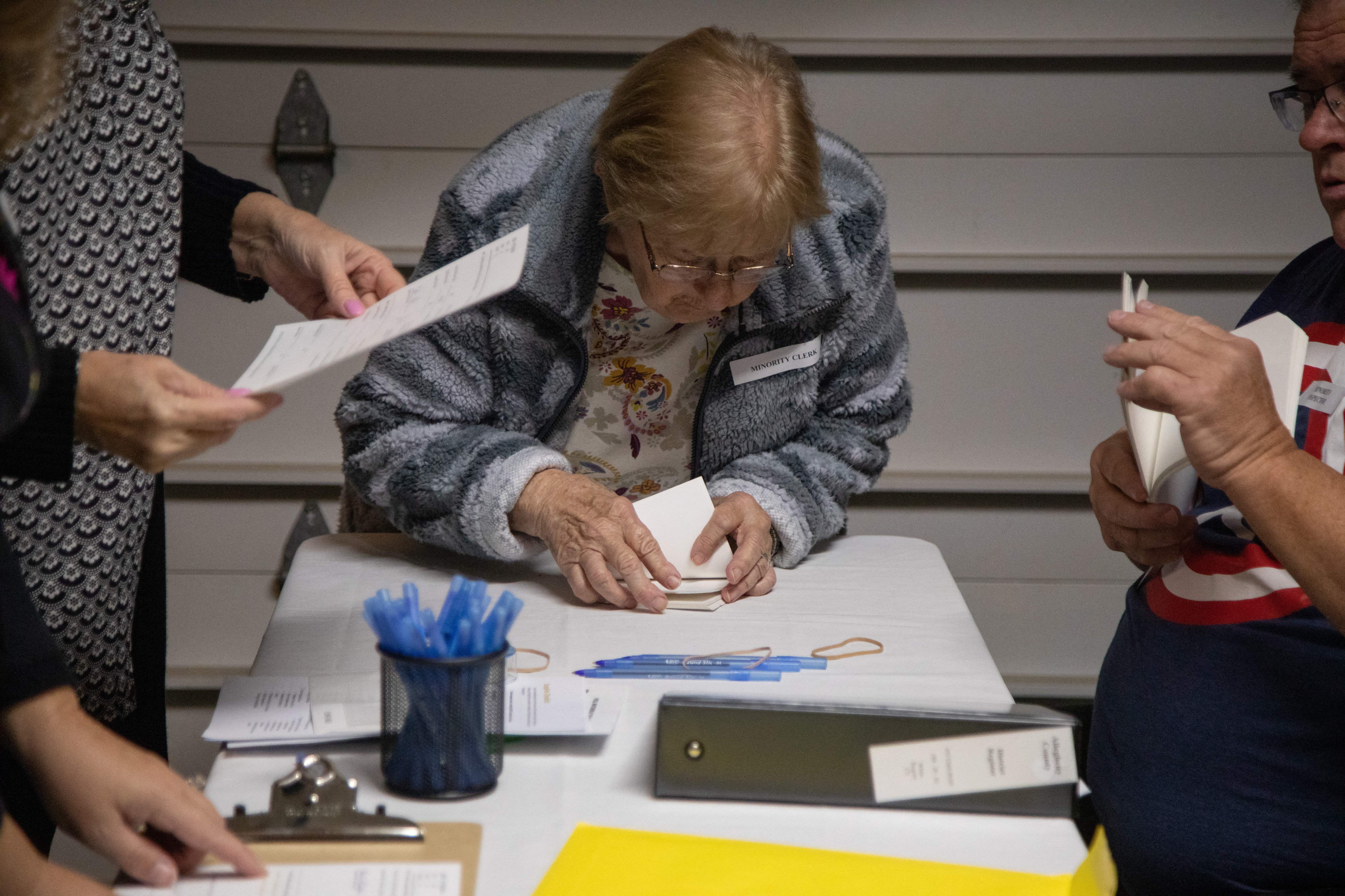 Rose English, minority clerk, center, and her son James English, right, minority inspector, prepare voting materials in a private residents garage, a polling place, before polls open during the US midterm elections, in Pittsburgh, Pennsylvania, on November 8, 2022. (Photo by Rebecca Droke/AFP via Getty Images)