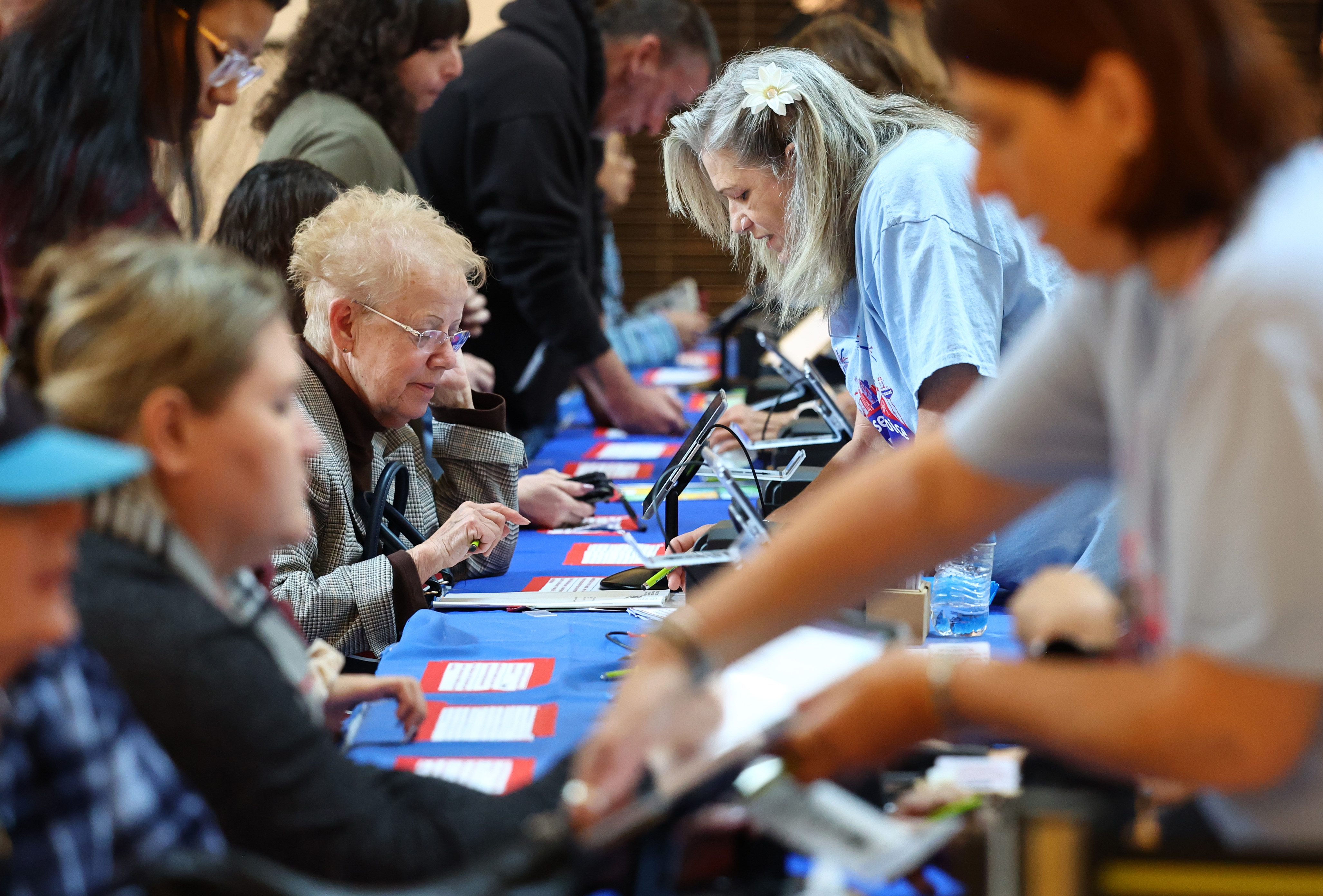 Election workers (R) check in voters at a polling place at Galleria at Sunset on November 08, 2022 in Henderson, Nevada. (Photo by Mario Tama/Getty Images)