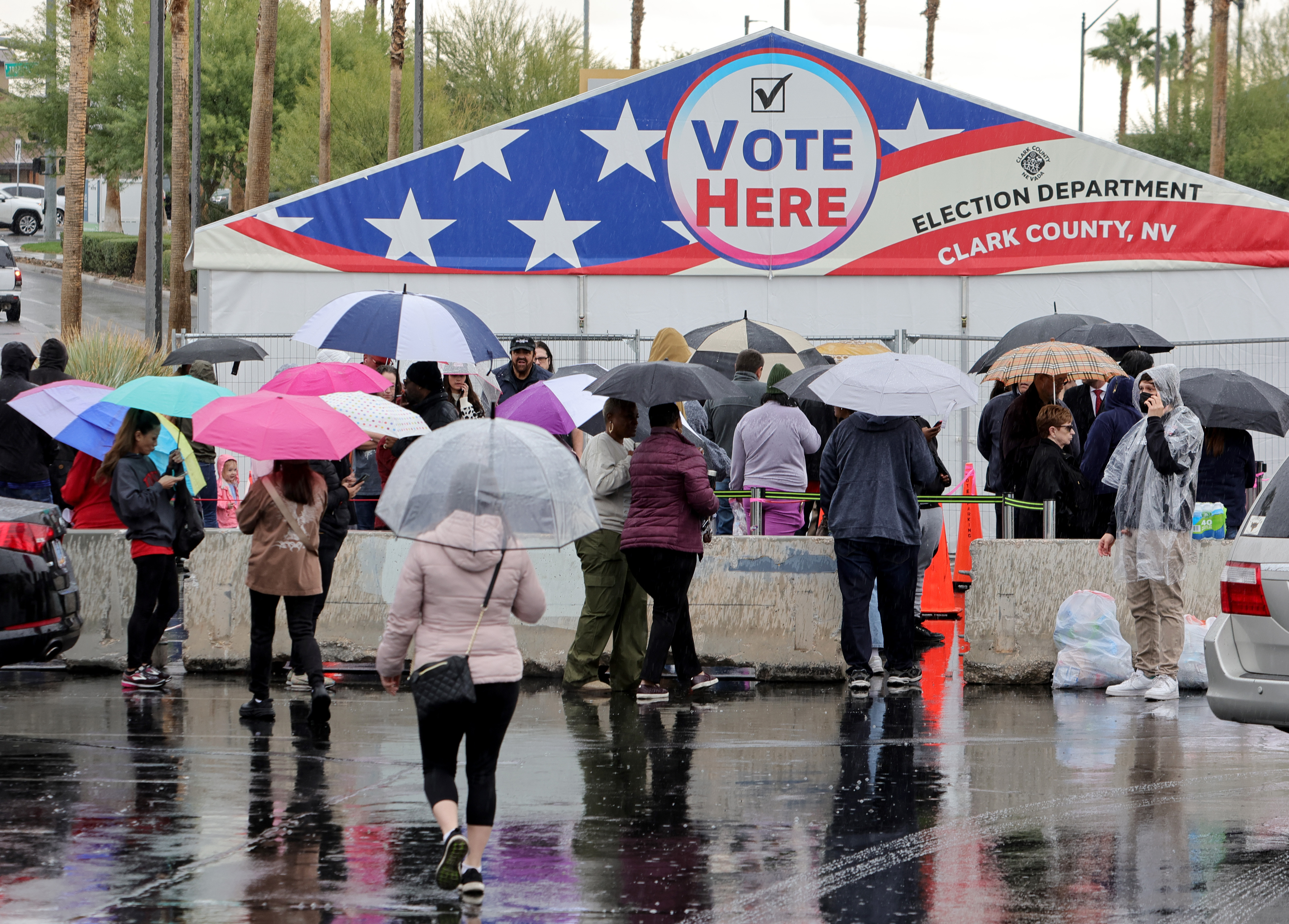 People line up in the rain to vote at a tent in a shopping center parking lot on November 08, 2022 in Las Vegas, Nevada. (Photo by Ethan Miller/Getty Images)