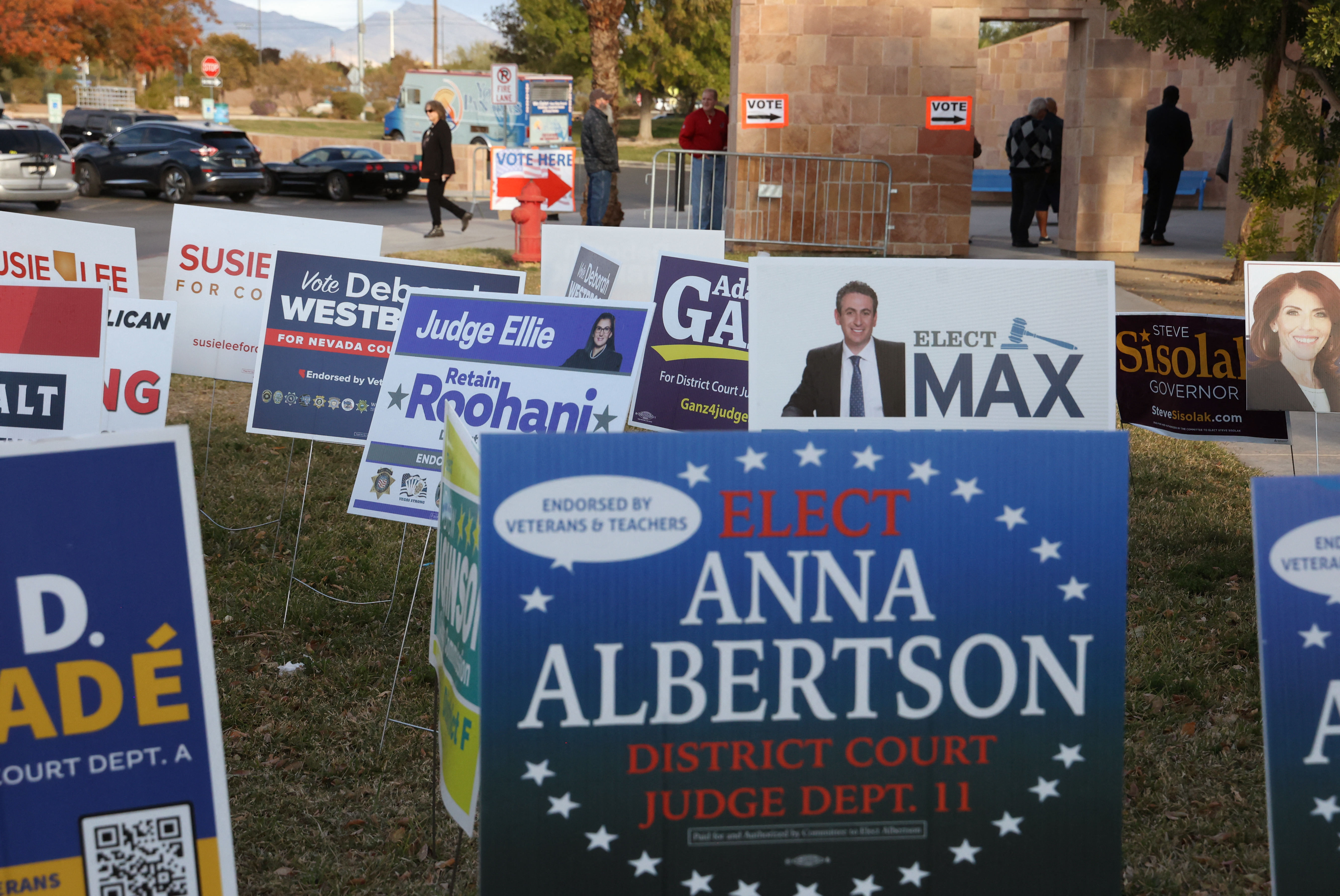 Campaign signs are shown near voters waiting in line at Desert Breeze Community Center on Election Day in Las Vegas, Nevada on November 8, 2022. (Photo by Ronda Churchill/AFP via Getty Images)