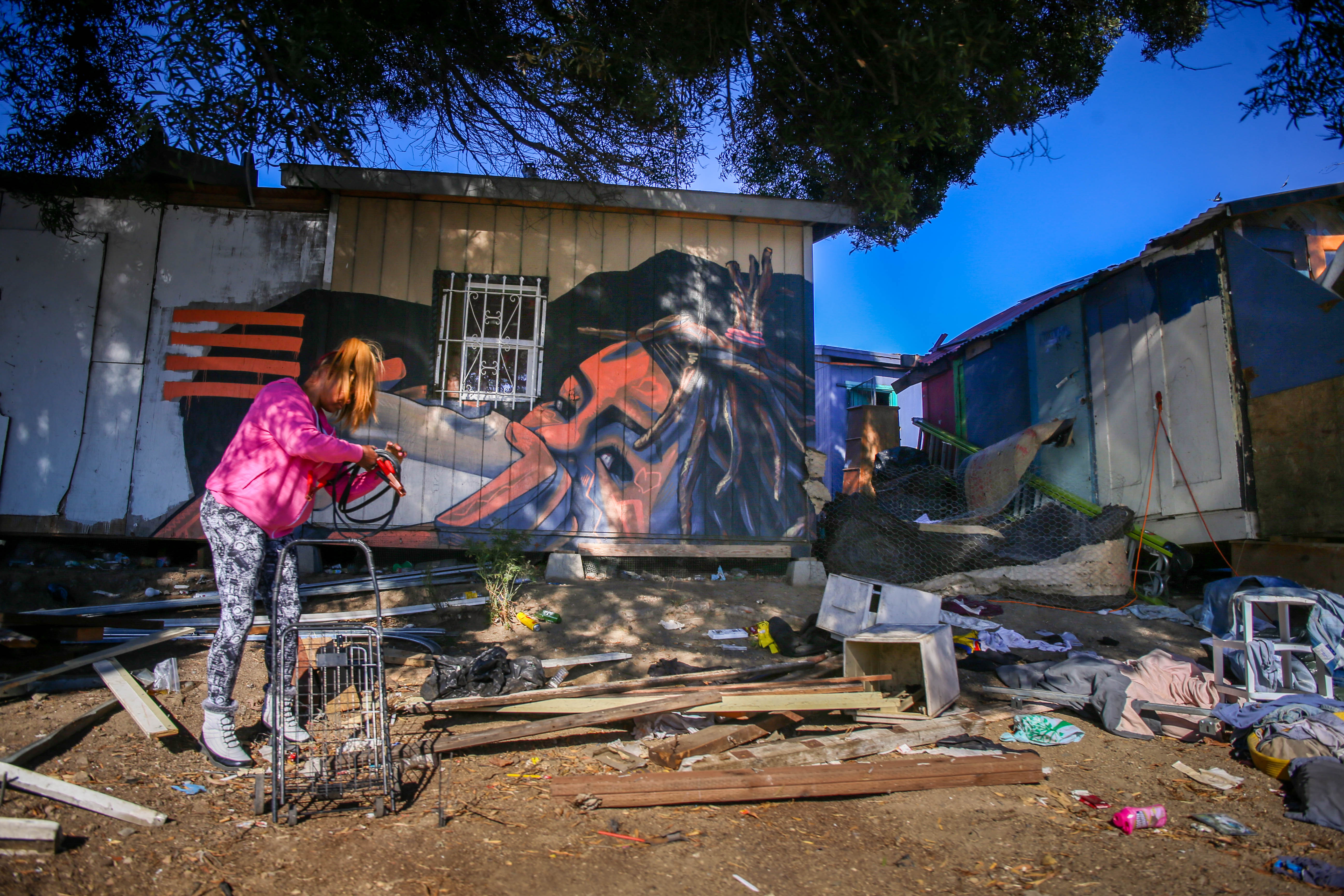 A person rolls up jumper cables at a homeless encampment on East 12th Street in Oakland, Calif., on Thursday, Nov. 3, 2022. (Ray Chavez/Bay Area News Group)