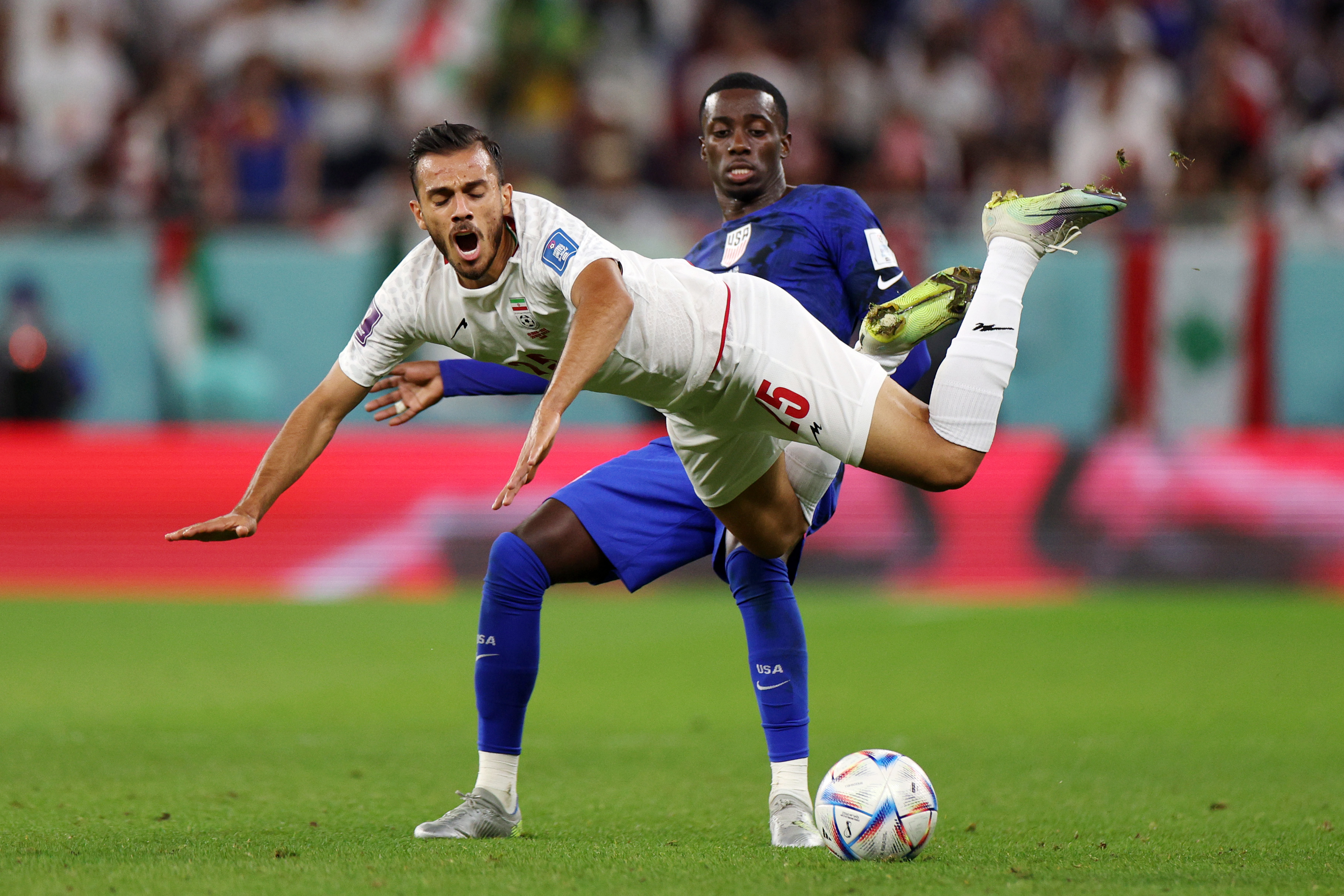 Roozbeh Cheshmi of IR Iran is fouled by Timothy Weah of United States during the FIFA World Cup Qatar 2022 Group B match between IR Iran and USA at Al Thumama Stadium on November 29, 2022 in Doha, Qatar. (Photo by Dean Mouhtaropoulos/Getty Images)