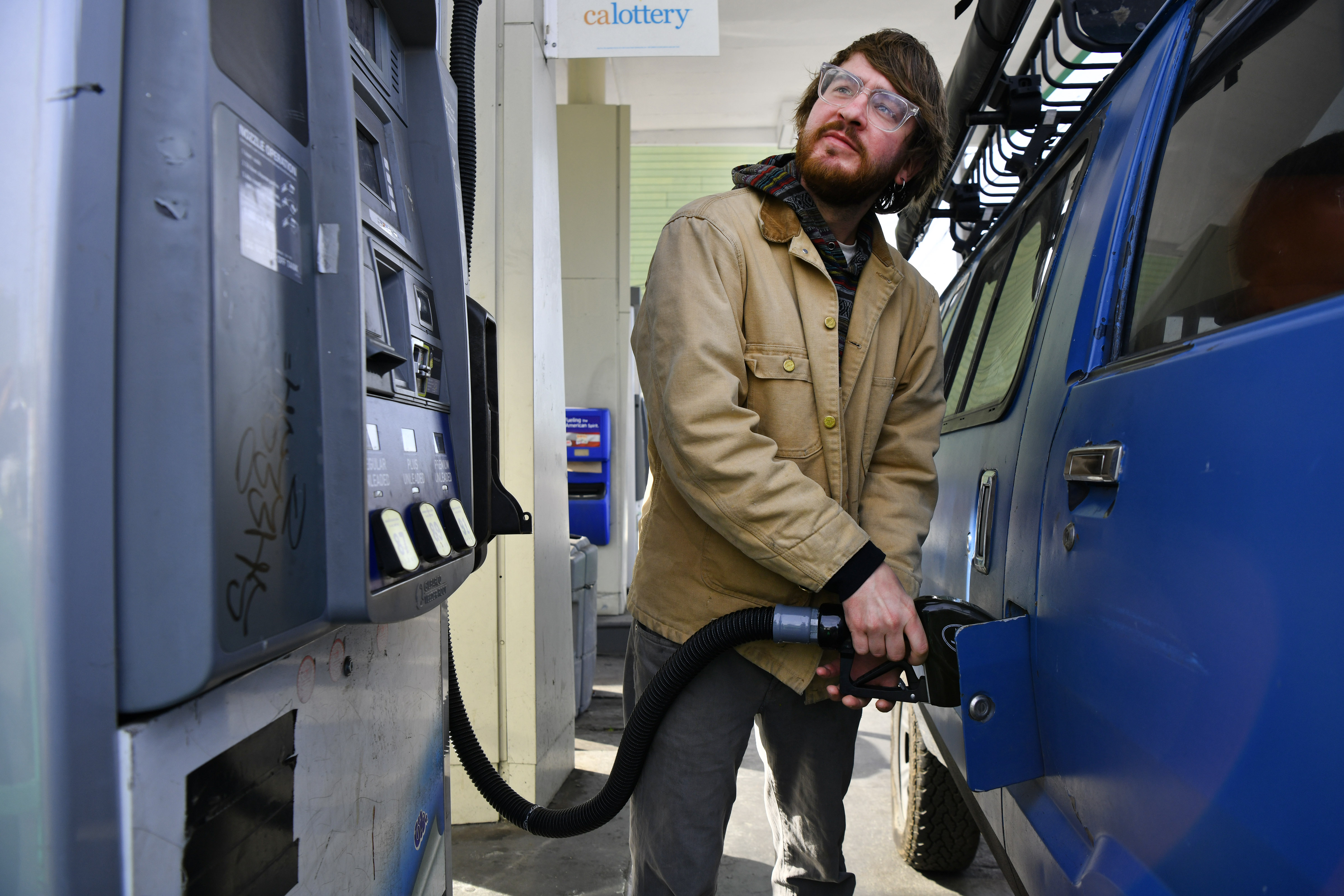 Jan Purat, 31, of Berkeley, pumps gas at the Berkeley Gas and Smog station in Berkeley, Calif., on Monday, Nov. 21, 2022. Purat plans to travel for Thanksgiving by flying to Phoenix. (Jose Carlos Fajardo/Bay Area News Group)