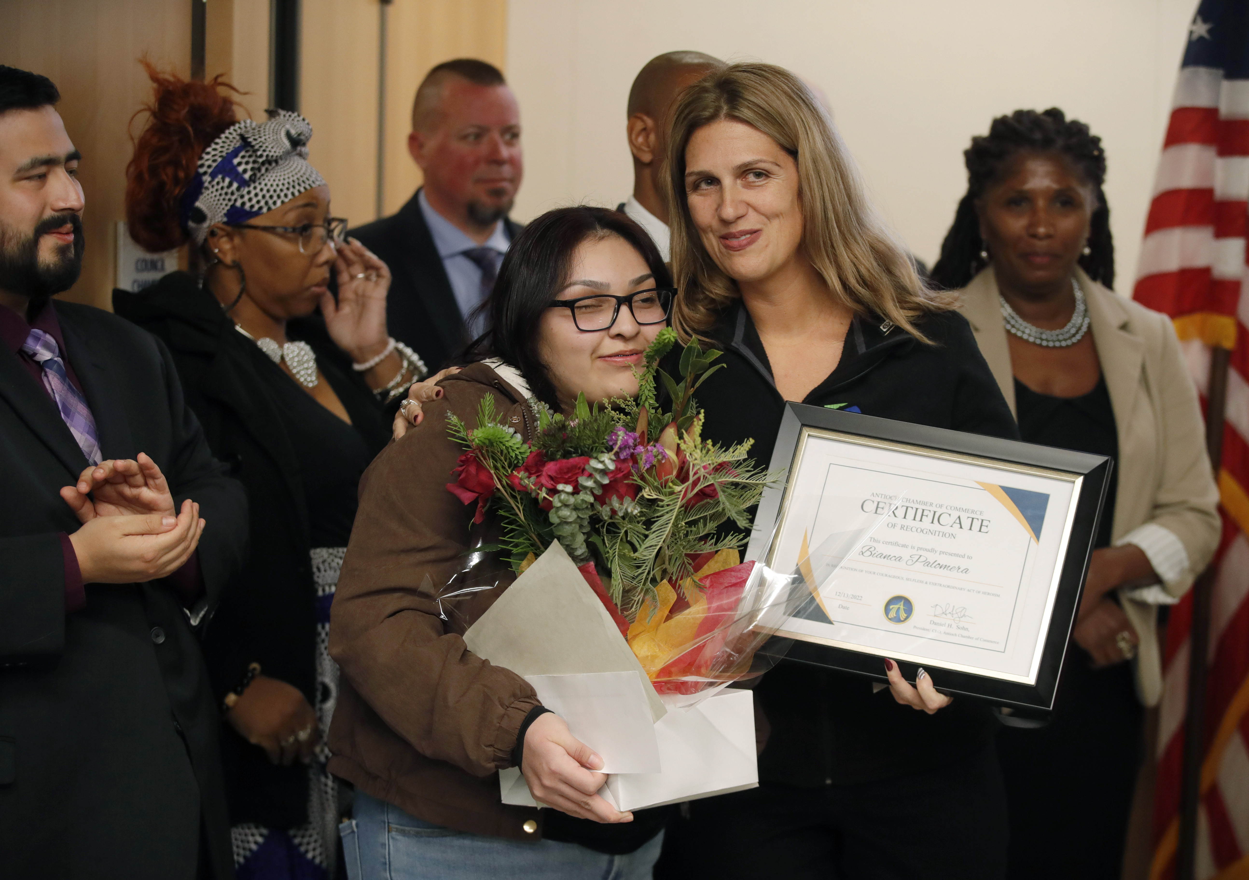 Bianca Palomera, left, receives a certificate from Ana Walker, of the Antioch Chamber of Commerce, during a ceremony at City Hall in Antioch, Calif., on Tuesday, Dec. 13, 2022. Palomera, 19, an employee at The Habit in Antioch, defended an autistic child who was being bullied, and lost her right eye after she was punched by the suspect, Isaac White-Carter, 20. (Jane Tyska/Bay Area News Group)