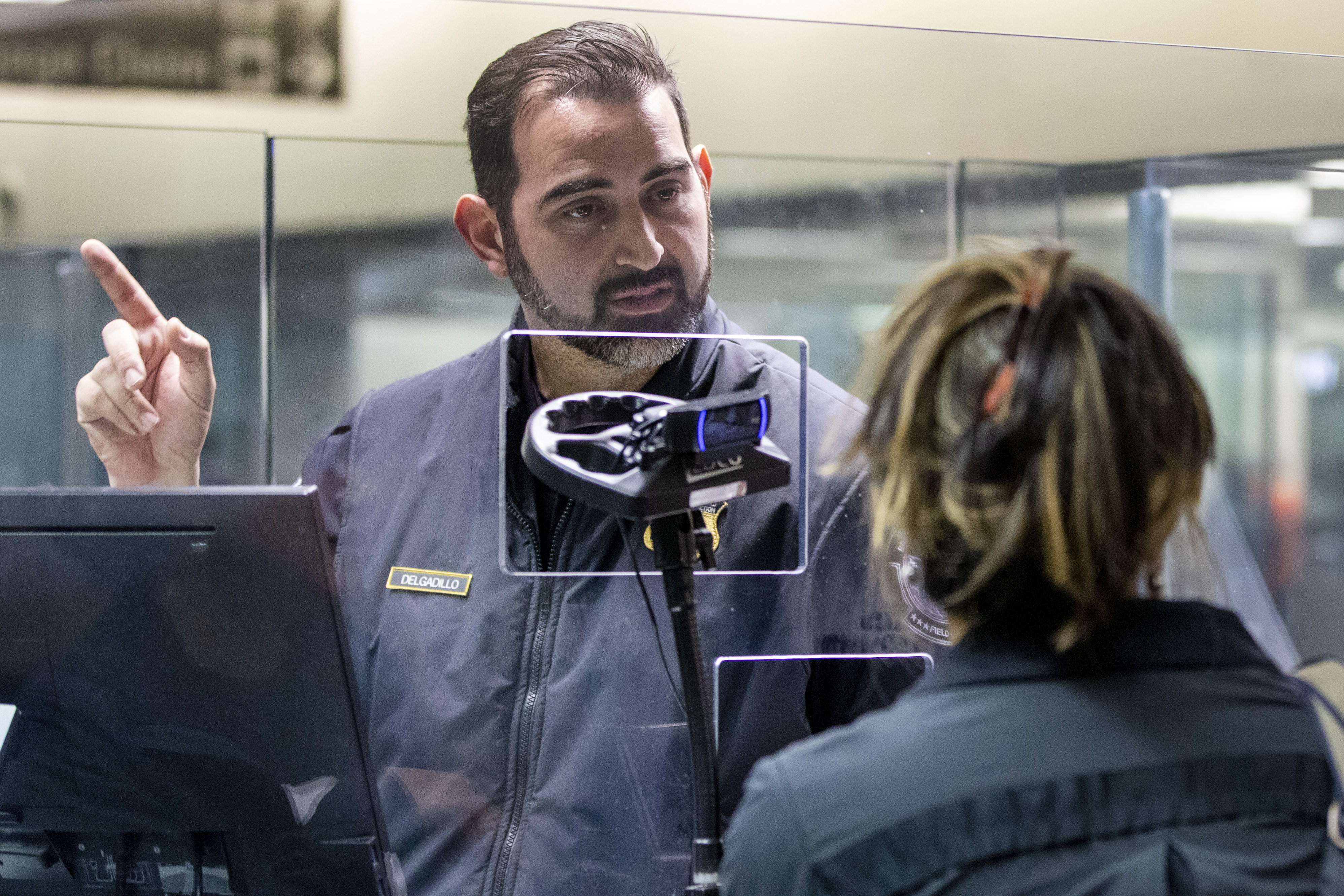 A US customs officer at San Francisco International Airport processes arriving passengers with the use of a camera connected to a facial comparison technology called Simplified Arrival, Wednesday, Dec. 14, 2022.