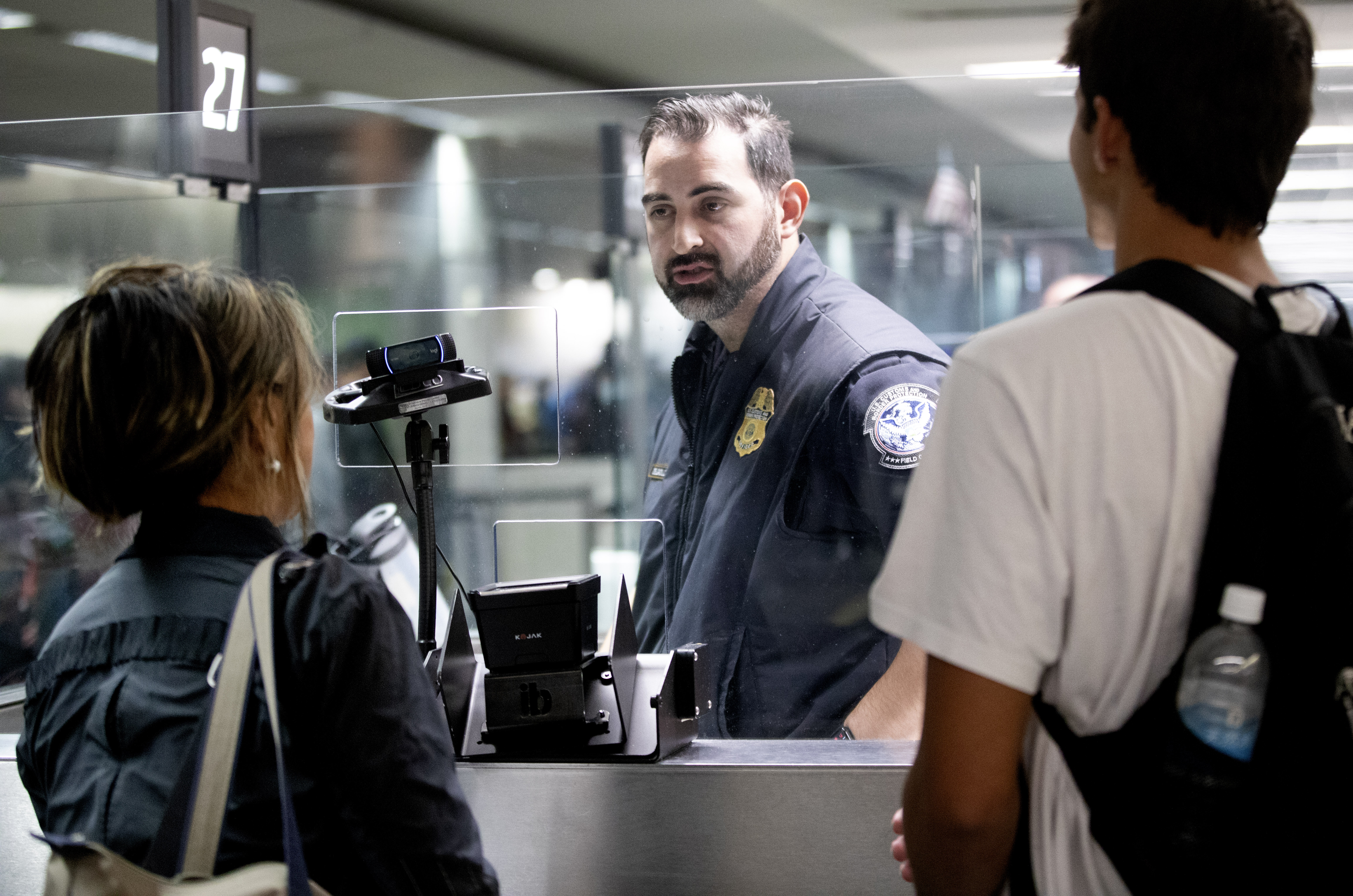 A US customs officer at San Francisco International Airport processes arriving passengers with the use of a camera connected to a facial comparison technology called Simplified Arrival, Wednesday, Dec. 14, 2022.