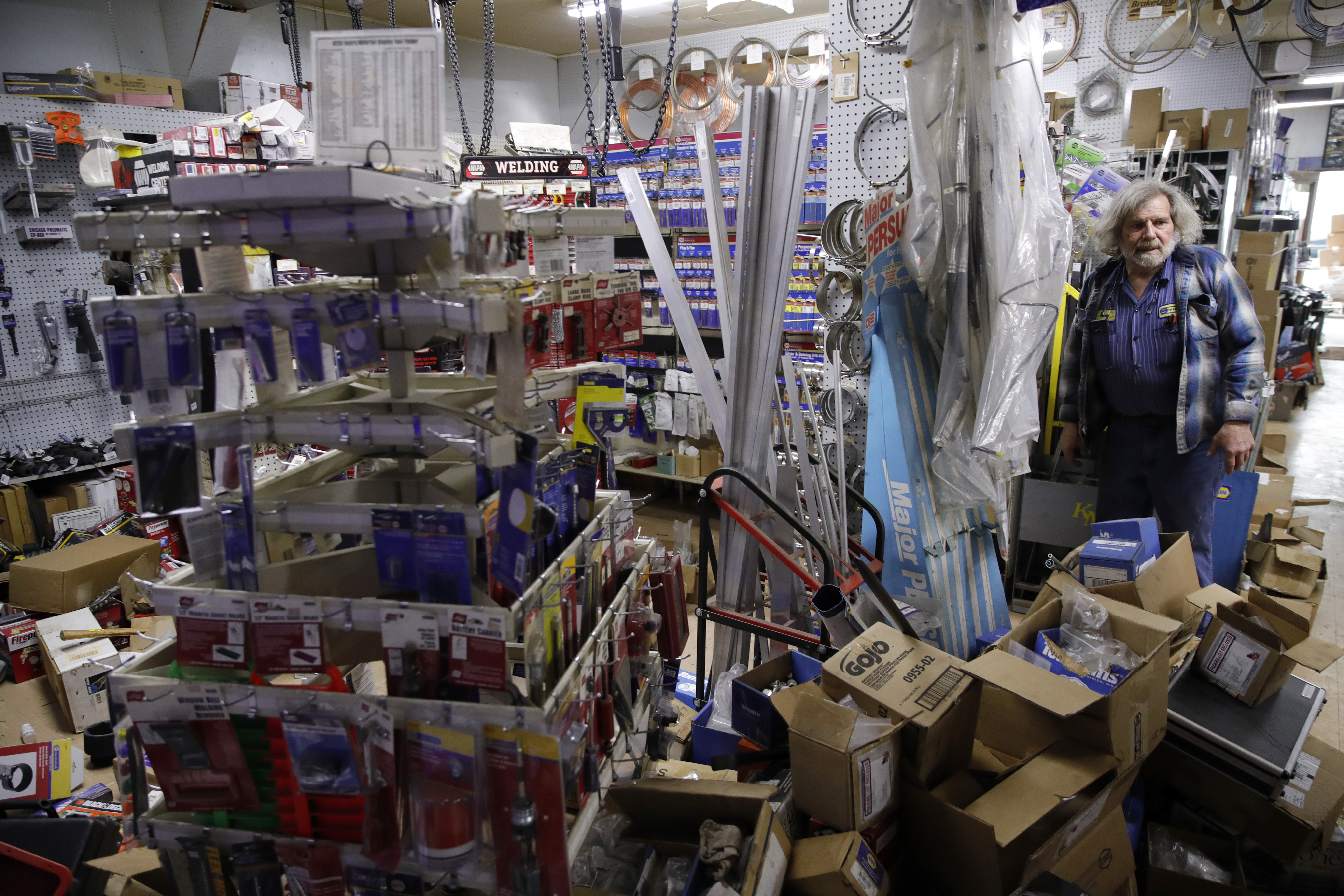 NAPA Auto Parts store owner Kenny Ransbottom cleans up earthquake damage at the store in Rio Dell, Calif., on Tuesday, Dec. 20, 2022.