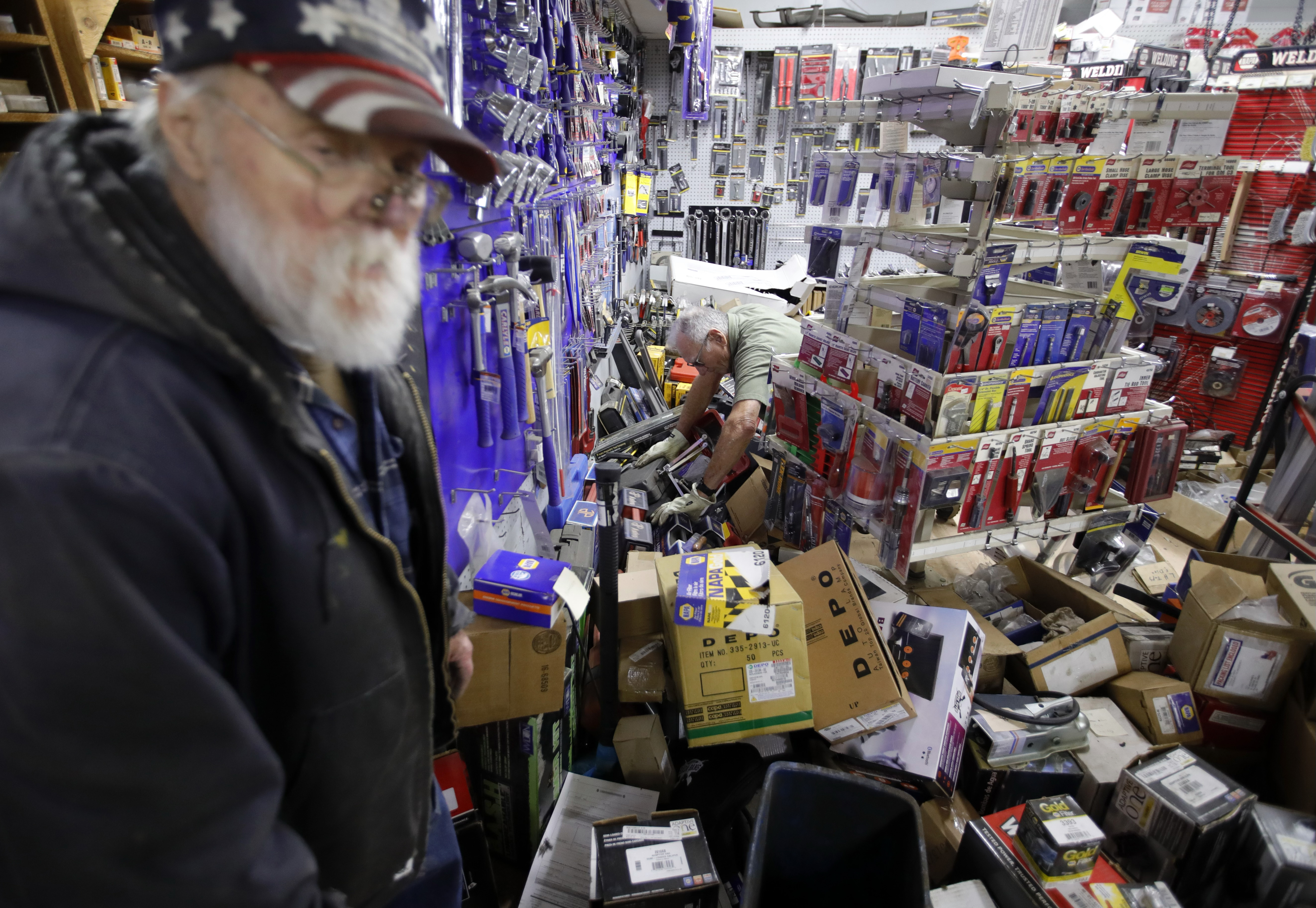 George Schauer, of Fairfield, brother-in-law of NAPA Auto Parts store owner Kenny Ransbottom, helps clean up earthquake damage in Rio Dell, Calif., on Tuesday, Dec. 20, 2022. To the left is employee Jim Boyd.