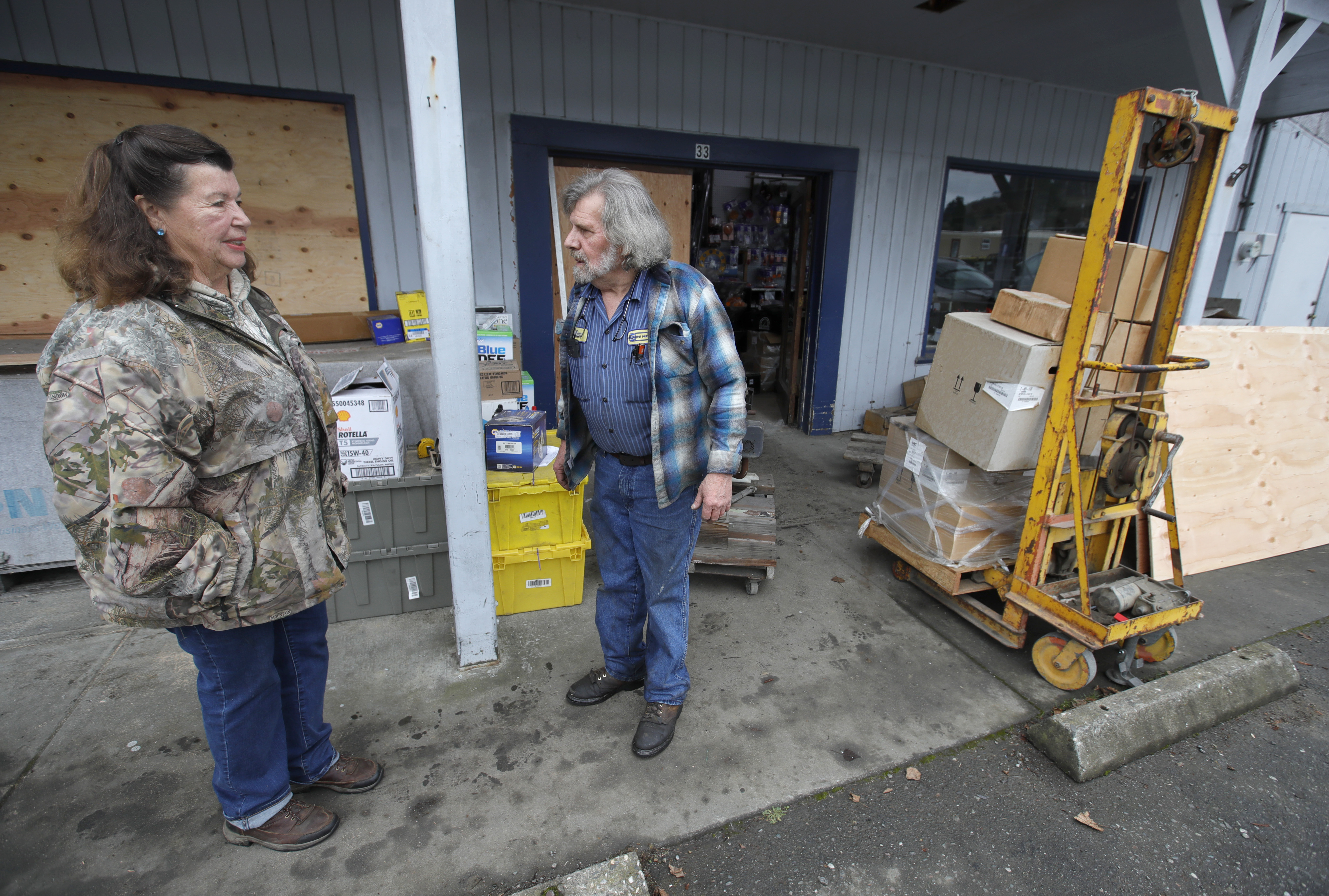 Johanna Rodoni, left, talks with NAPA Auto Parts store owner Kenny Ransbottom as he cleans up from earthquake damage in Rio Dell, Calif., on Tuesday, Dec. 20, 2022. 