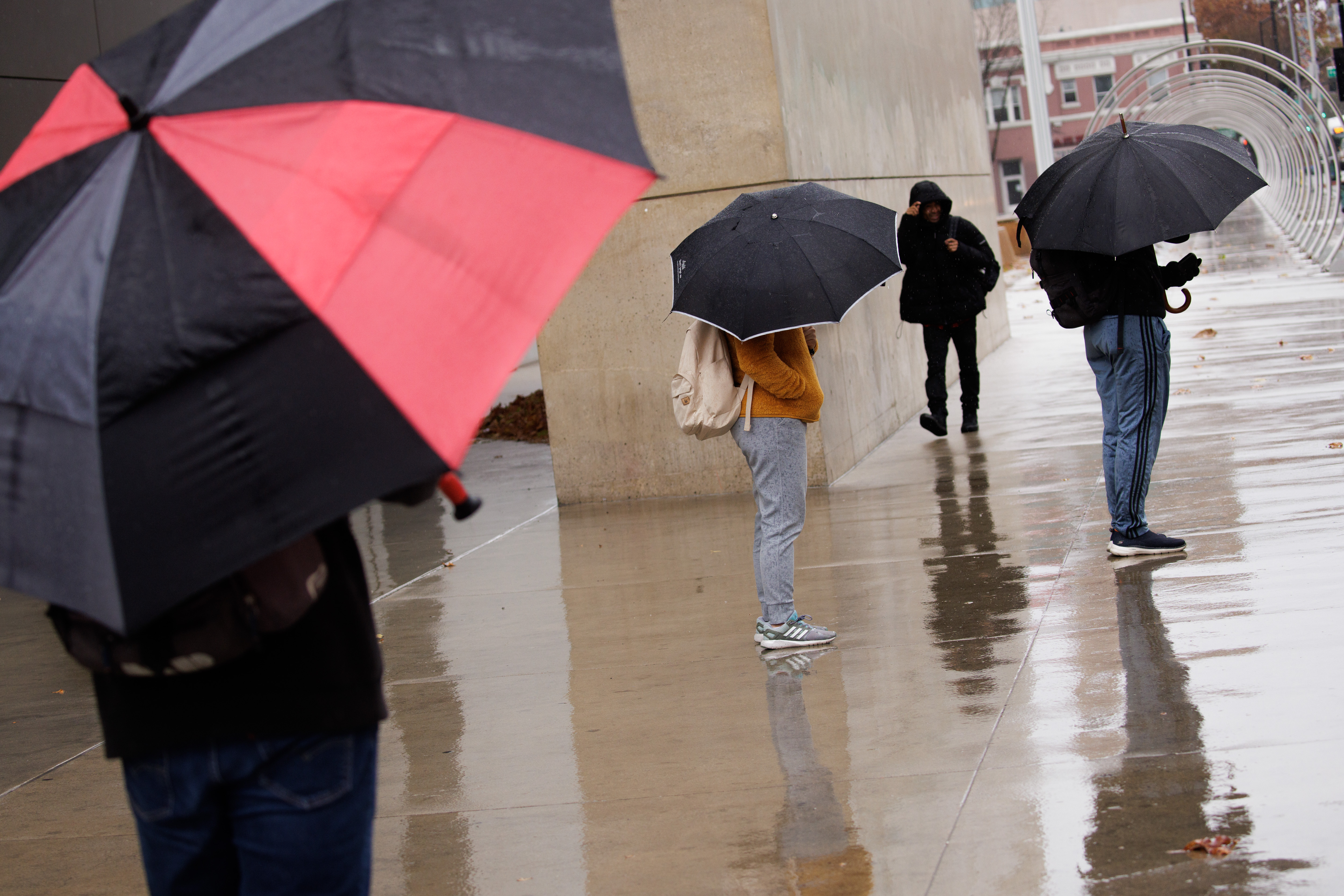 Pedestrians wait at a bus stop on a rainy day in downtown San Jose on Thursday, Dec. 1, 2022. (Dai Sugano/Bay Area News Group)