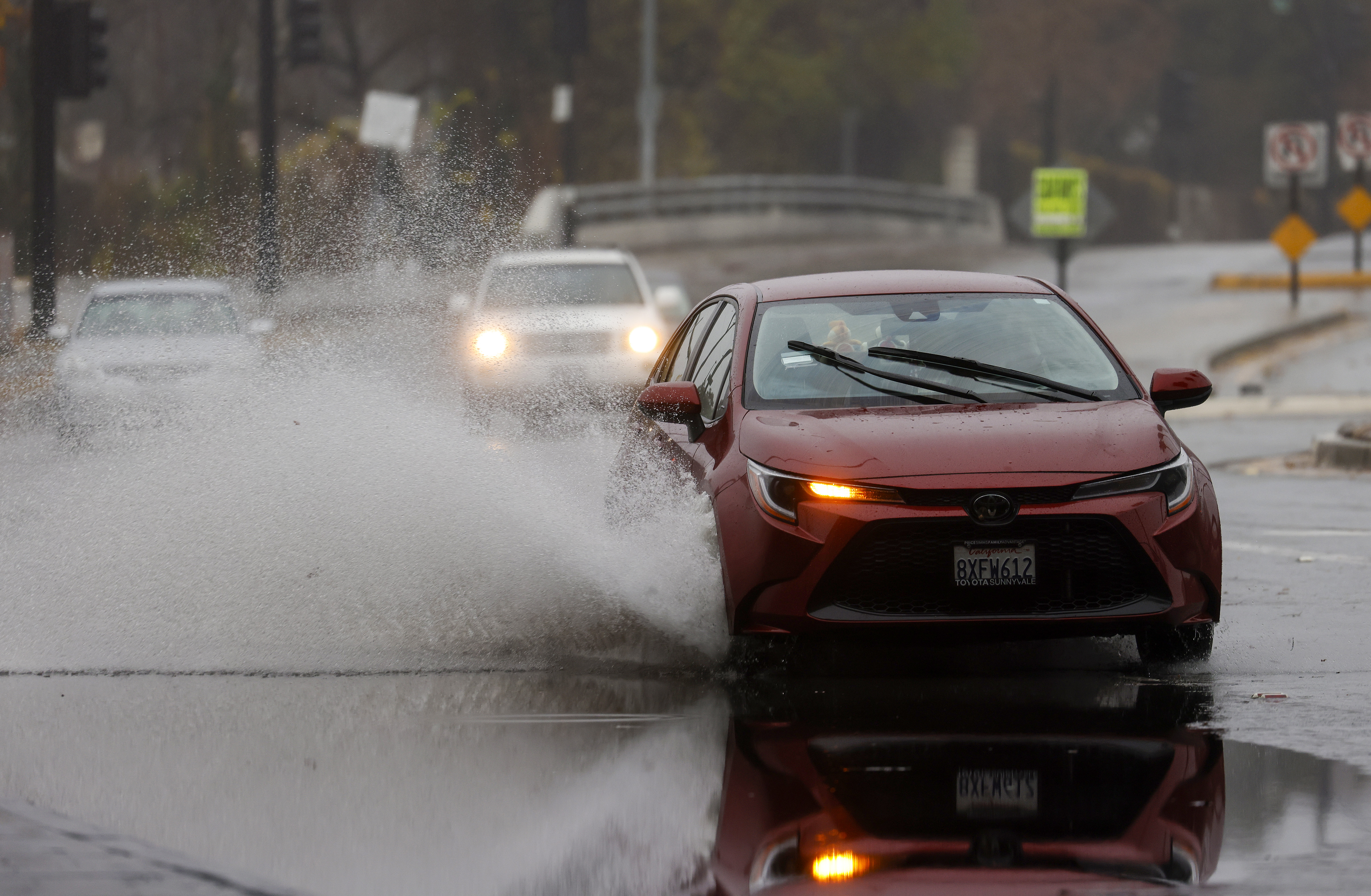 A car drives through a partial flooded Julian Street under Highway 87 in downtown San Jose, Calif., on Tuesday, Dec. 27, 2022. (Nhat V. Meyer/Bay Area News Group)