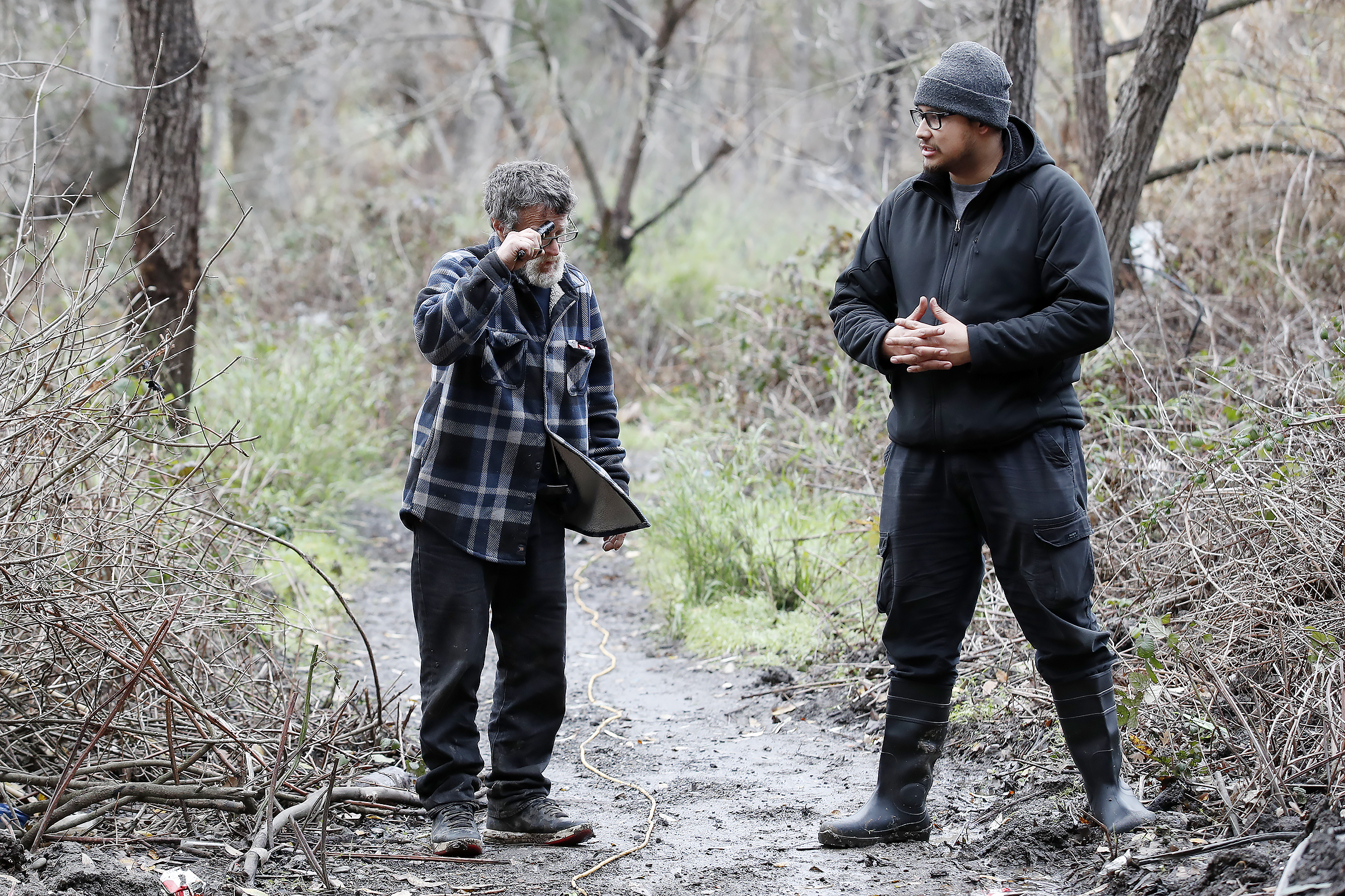 Unhoused Robert Moffitt, 63, talks with Branden Sanchez, of Lighthouse Food Rescue and Distribution, as he informs them of the evacuation center. Roberts' tent was flooded on Sunday at Los Lagos encampment at Lone Bluff Park in San Jose, Calif., on Wednesday, Jan. 4, 2023.