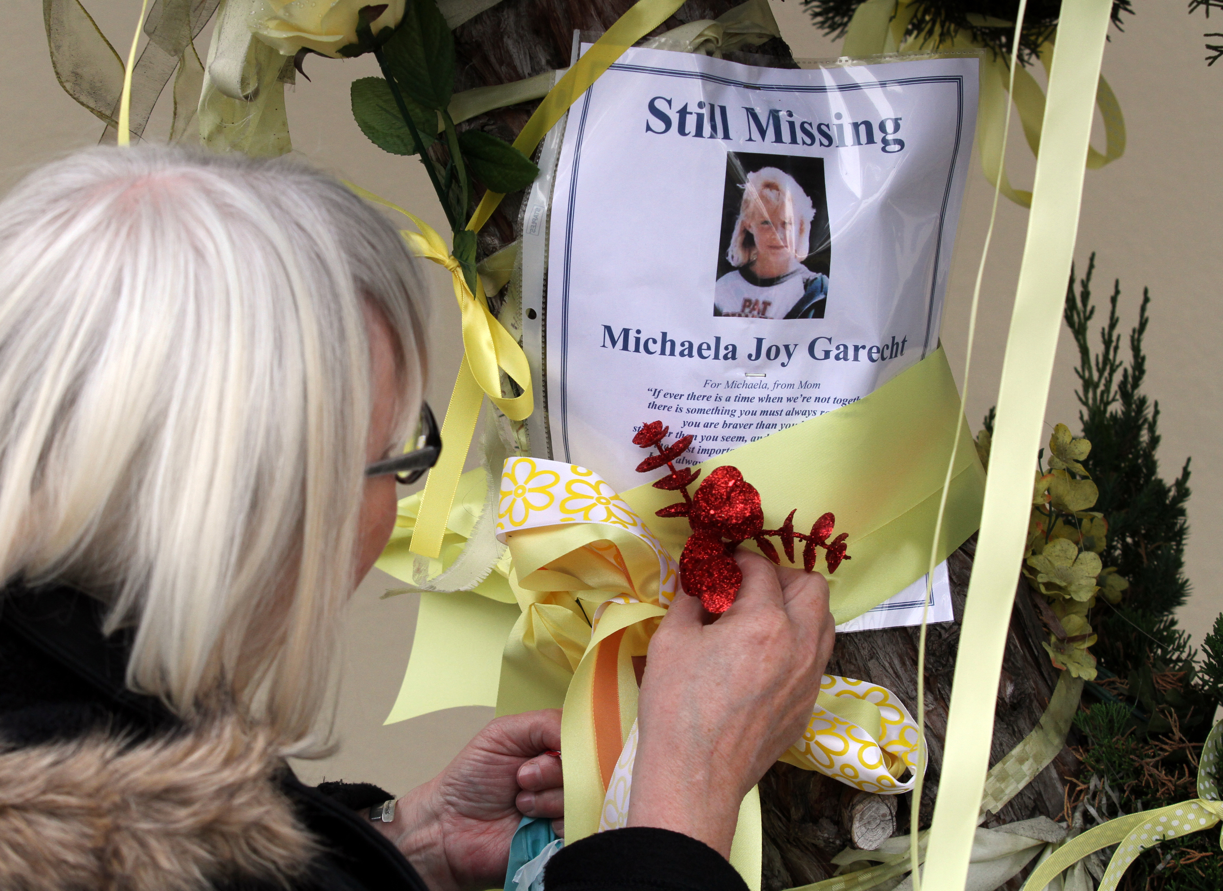 In November 2013, family and friends gather to mark the day that Michaela Garecht was abducted 25 years ago from a parking lot off Mission Boulevard and Lafayette Avenue in Hayward. Her morther, Sharon Murch decorates a tree with yellow ribbons.