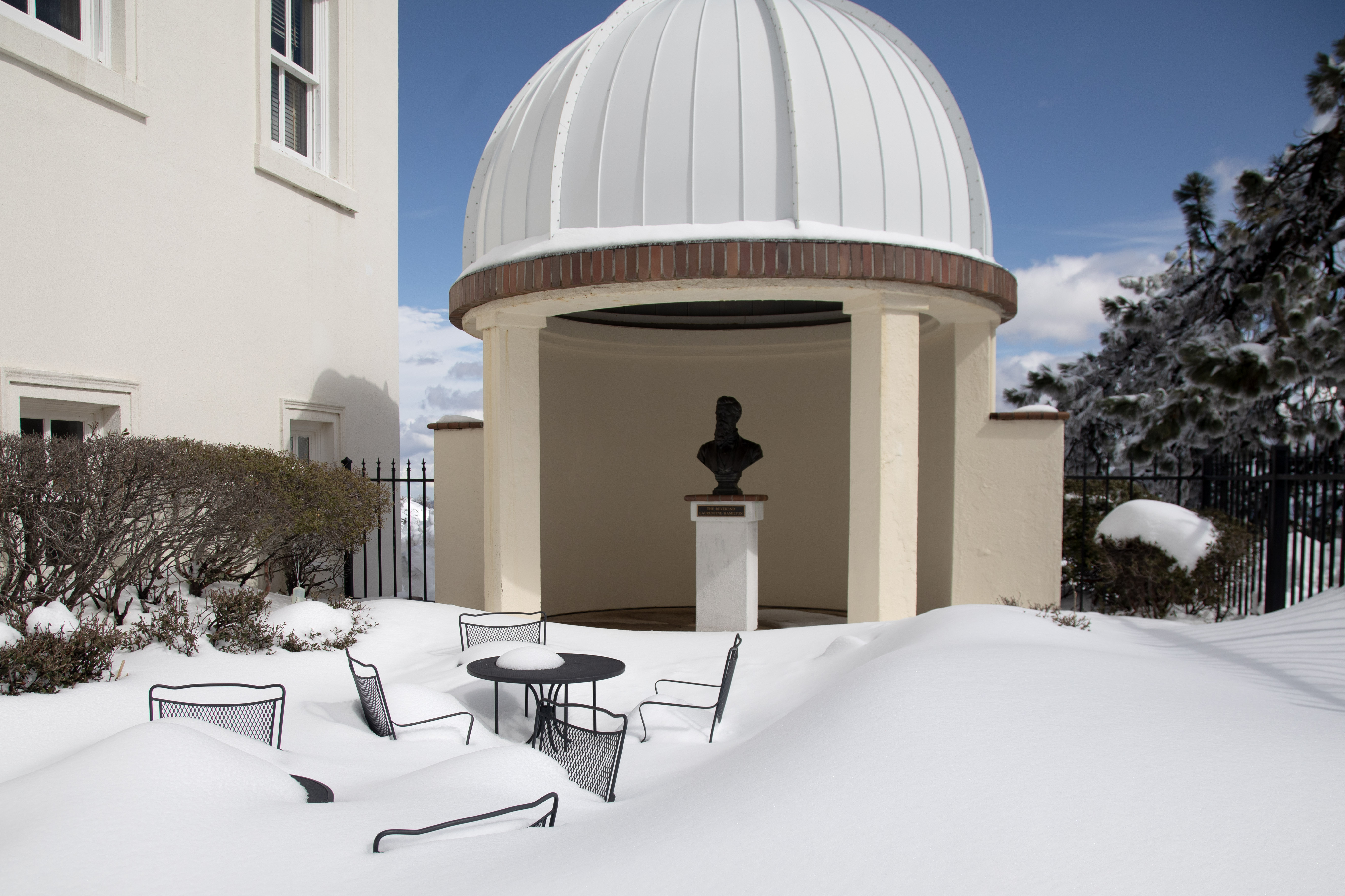 Patio furniture at Lick Observatory is buried in the snow, Tuesday, March 7, 2023, near a bust of Laurentine Hamilton, Mount Hamilton's namesake.