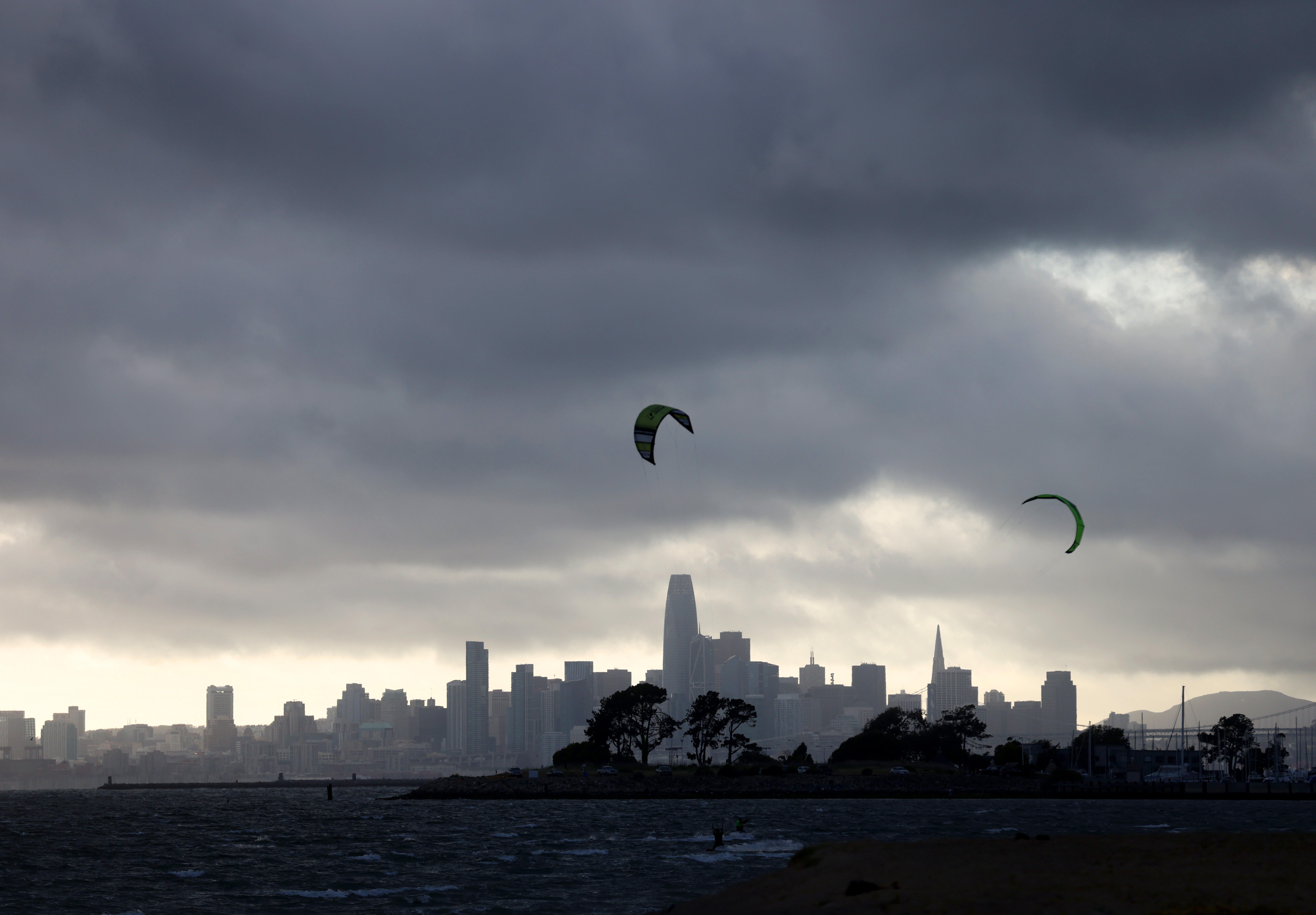 Dark clouds are seen over the San Francisco skyline as kiteboarders take advantage of windy conditions at Robert W. Crown Memorial State Beach in Alameda, Calif., on Monday, May 1, 2023. Rain is expected on Tuesday according to the National Weather Service. (Jane Tyska/Bay Area News Group)