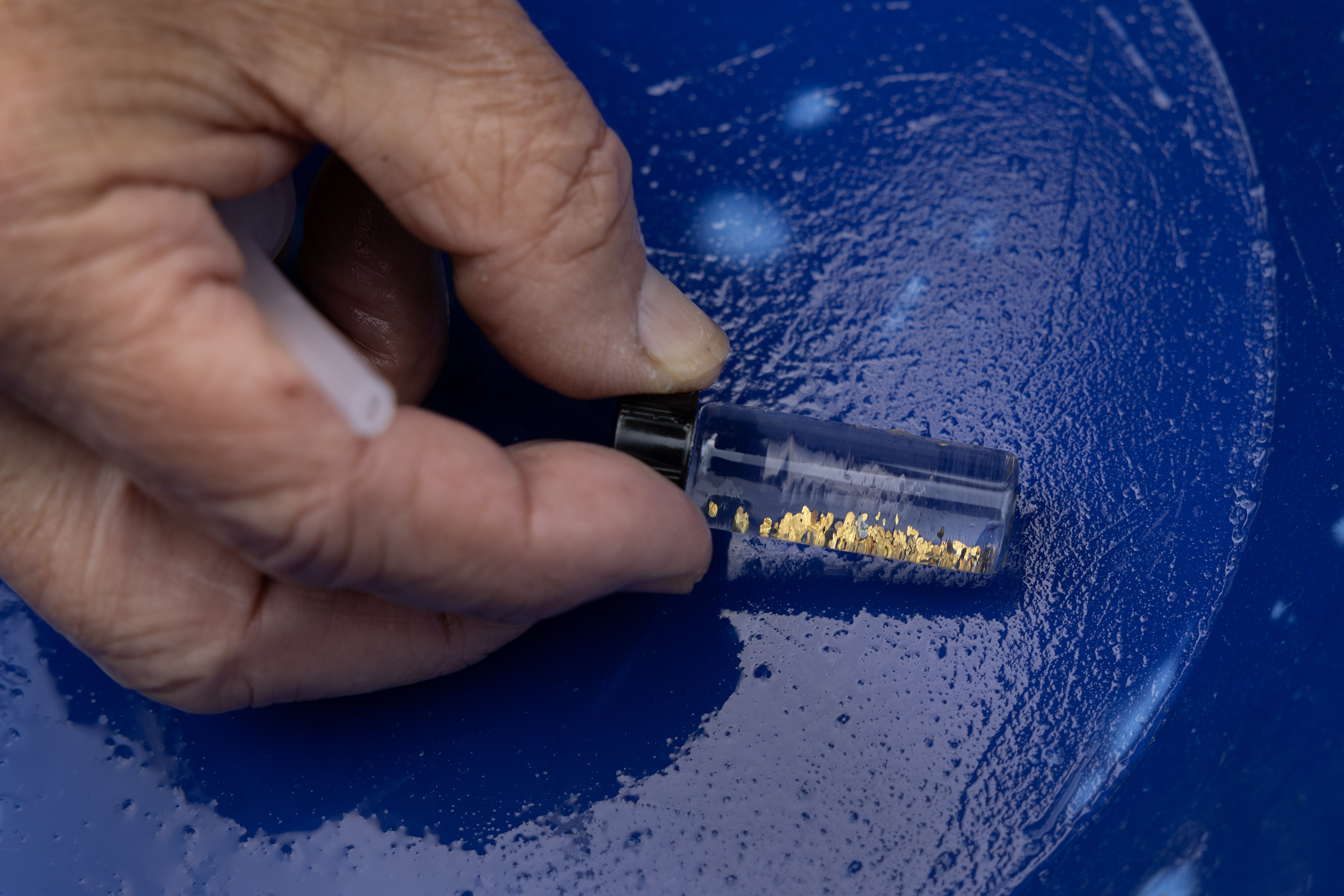 Kevin Bell, California director of Gold Prospectors of America, holds a vile of gold flakes he collected on Moore Creek near Buck Meadows, Calif., Tuesday, May 9, 2023. Winter storms sent water blasting through rocks in the Sierra Nevada, leading to what is widely anticipated to be the biggest discovery season in recent history. (Karl Mondon/Bay Area News Group)
