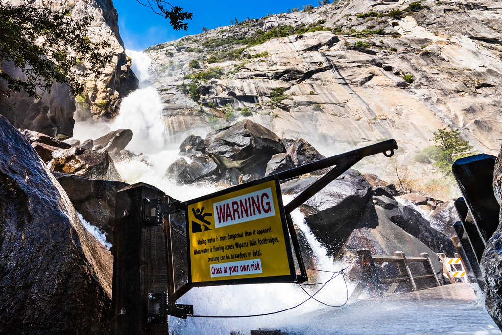 When the water flow is low, hiking out on the footbridges below Wapama Falls at Yosemite's Hetch Hetchy Reservoir can be fun. But when the waterfall turns into a thunderous cascade, best heed the warning signs and enjoy the spectacle from afar. (Getty Images) Warning sign due to Wapama Falls flowing over the footbridge and creating hazardous conditions for crossing; Hetch Hetchy Reservoir area, Yosemite National Park, California