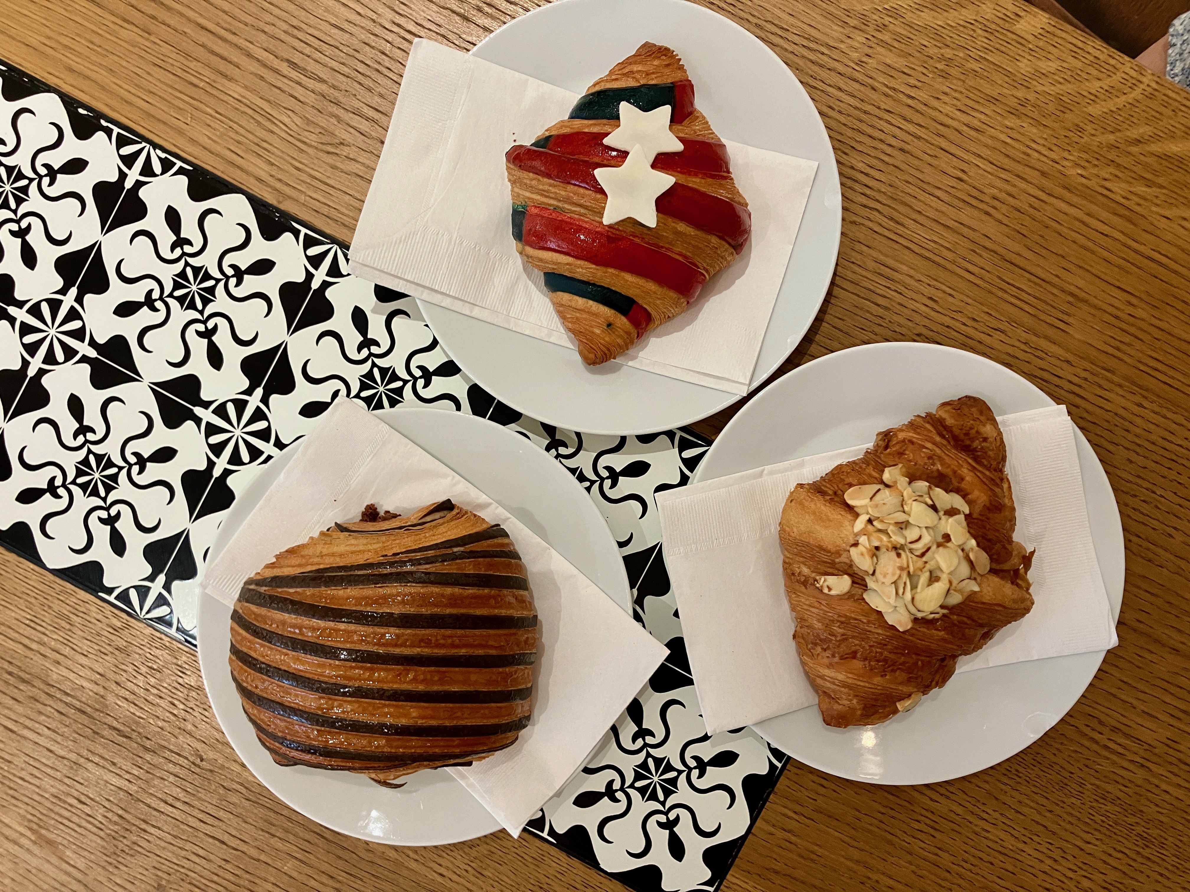 A hazelnut-chocolate croissant, Fourth of July-themed plain croissant and almond croissant are served at Maison Alyzée in Burlingame. (Kate Bradshaw/Bay Area News Group)