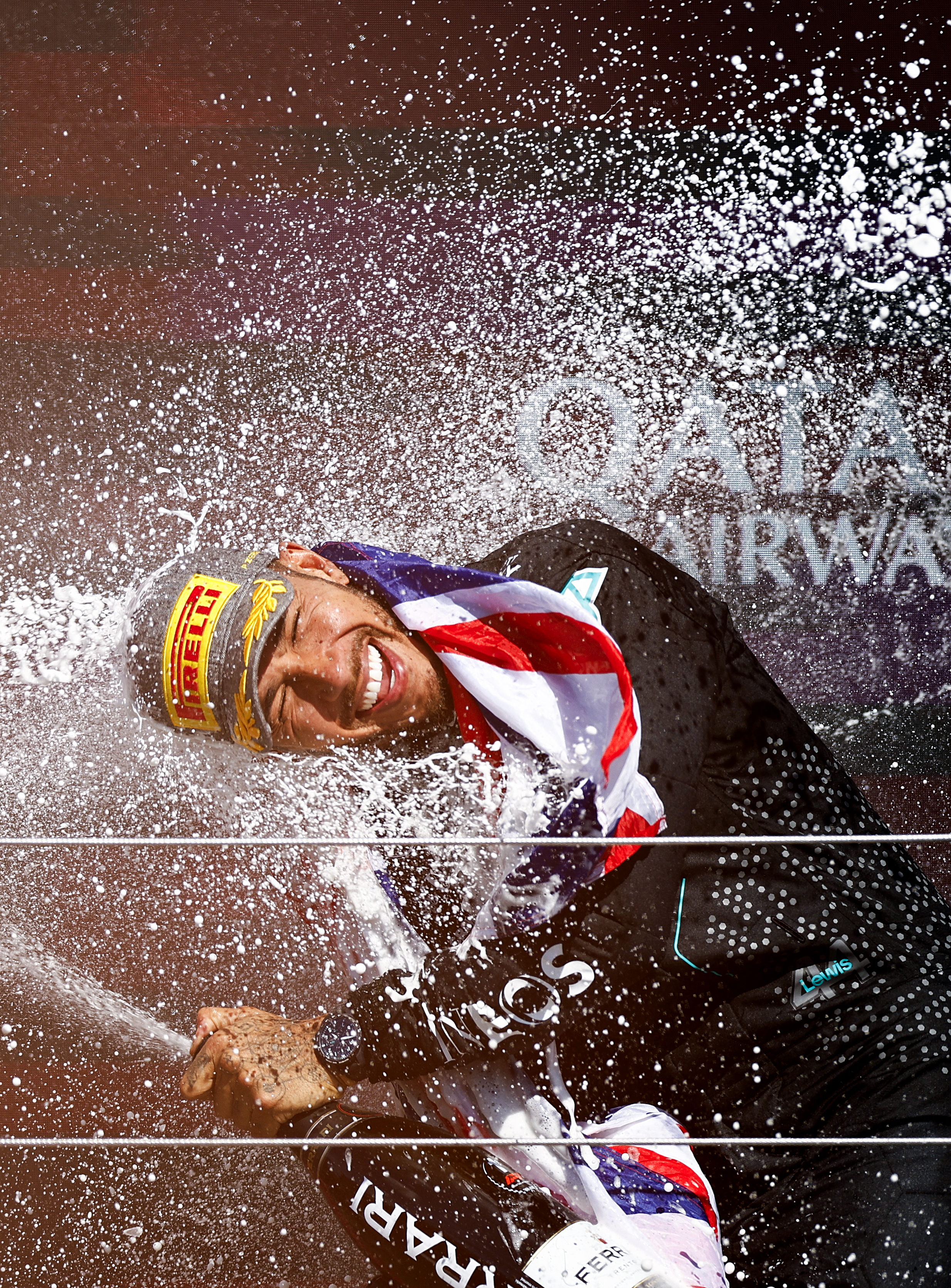 Mercedes' British driver Lewis Hamilton celebrates on the podium with champagne after winning the Formula One British Grand Prix at the Silverstone motor racing circuit in Silverstone, central England, on July 7, 2024. (Photo by BENJAMIN CREMEL / AFP) (Photo by BENJAMIN CREMEL/AFP via Getty Images)