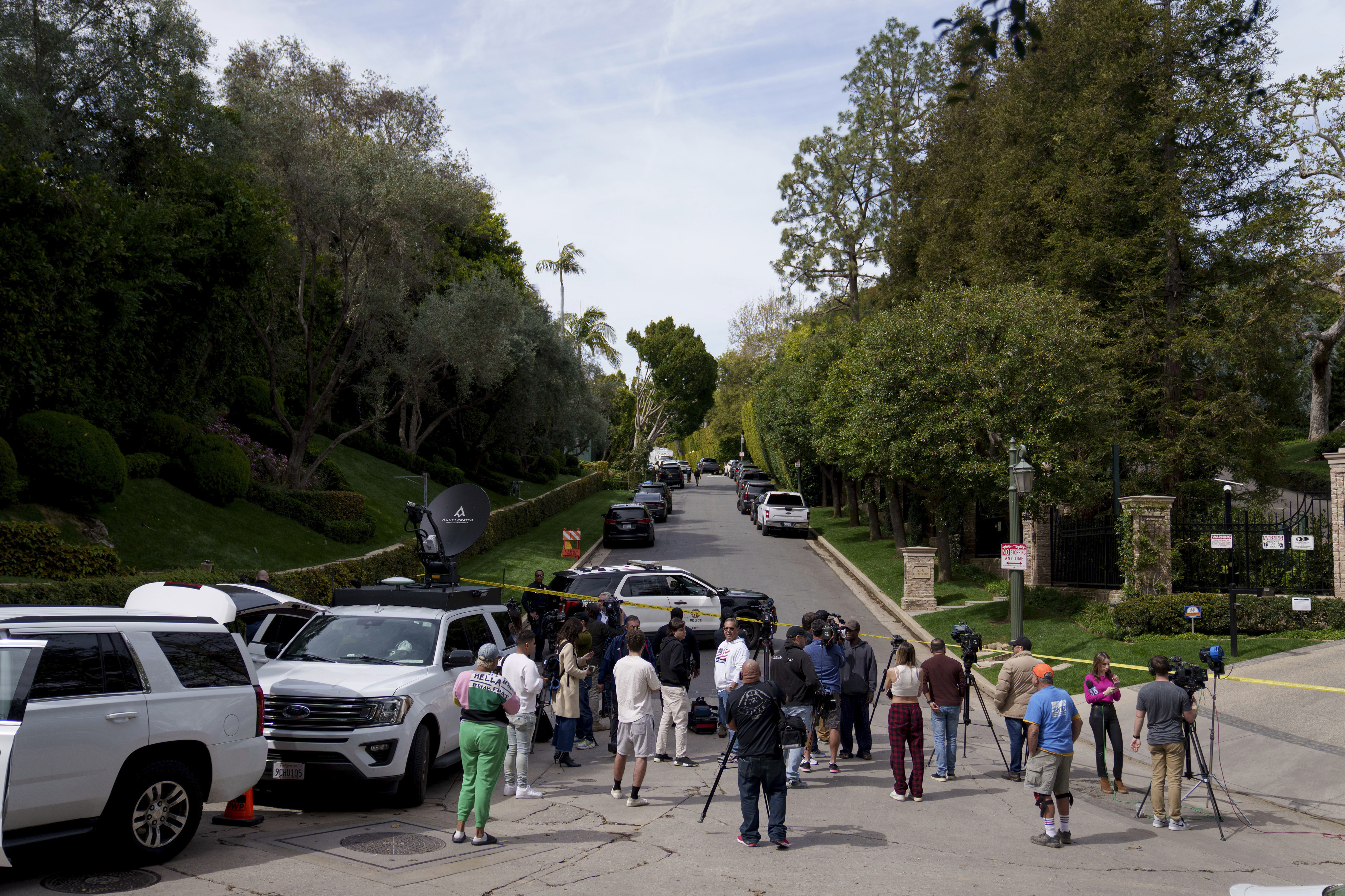 Media gathers as law enforcement blocks a street in front of a property belonging to Sean "Diddy" Combs on Monday, March 25, 2024, in Los Angeles. (AP Photo/Eric Thayer)