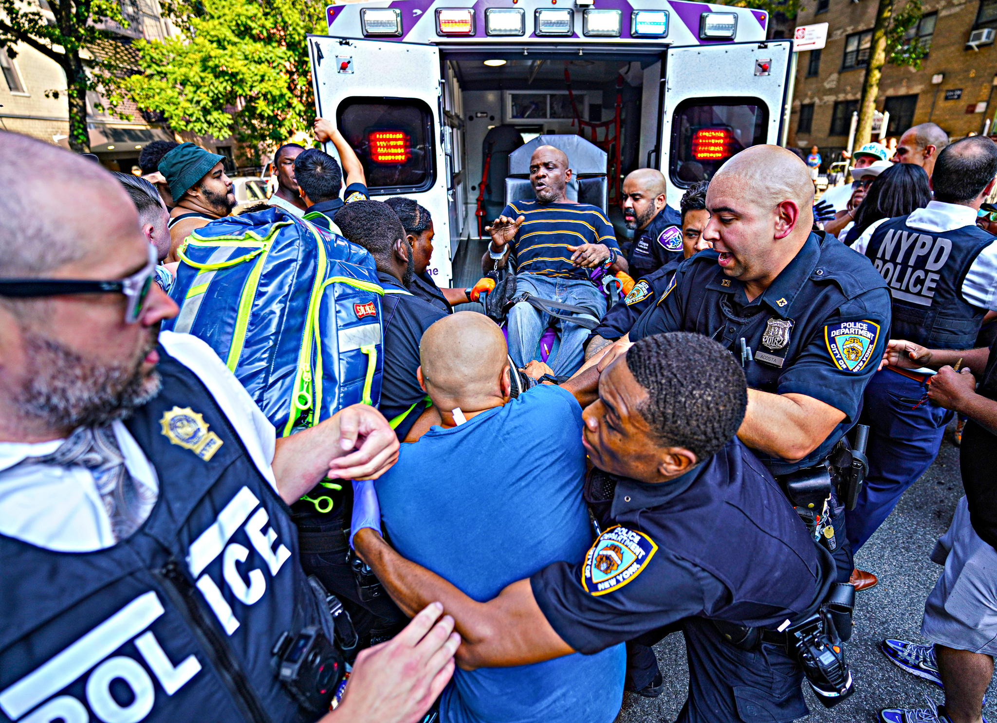 Police take a man into custody on a stretcher, as an angry mob tries to get at him, Monday, July 8, 2024, in Manhattan, New York. (Photo by Dean Moses / amNewYork)