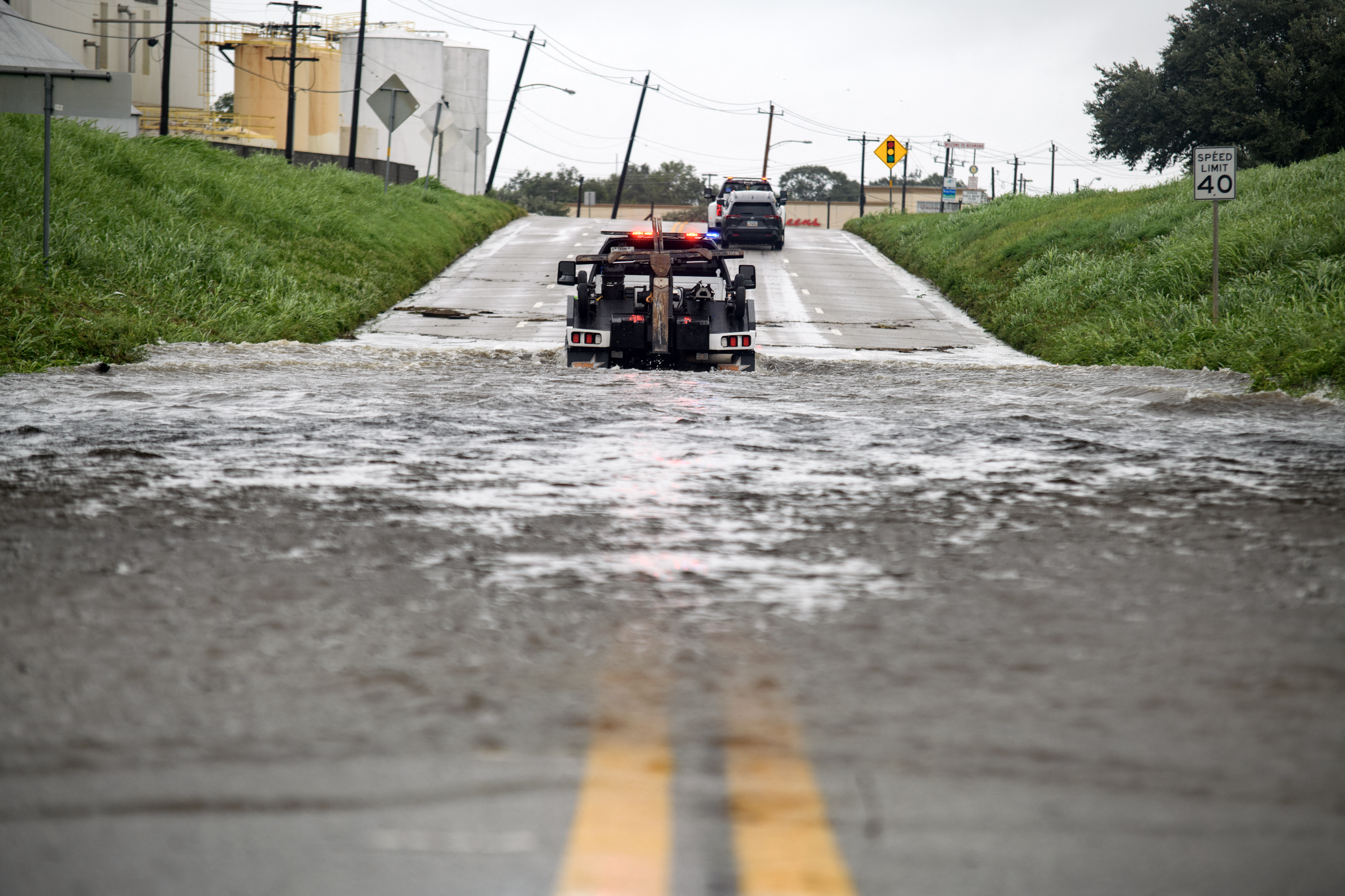 Tow trucks drive through high water after pulling a vehicle out in Rosenberg, Texas, on July 8, 2024. Hurricane Beryl made landfall Monday in the southern US state of Texas, where some residents were evacuated over warnings of flooding and power outages. (Photo by Mark Felix / AFP) (Photo by MARK FELIX/AFP /AFP via Getty Images)