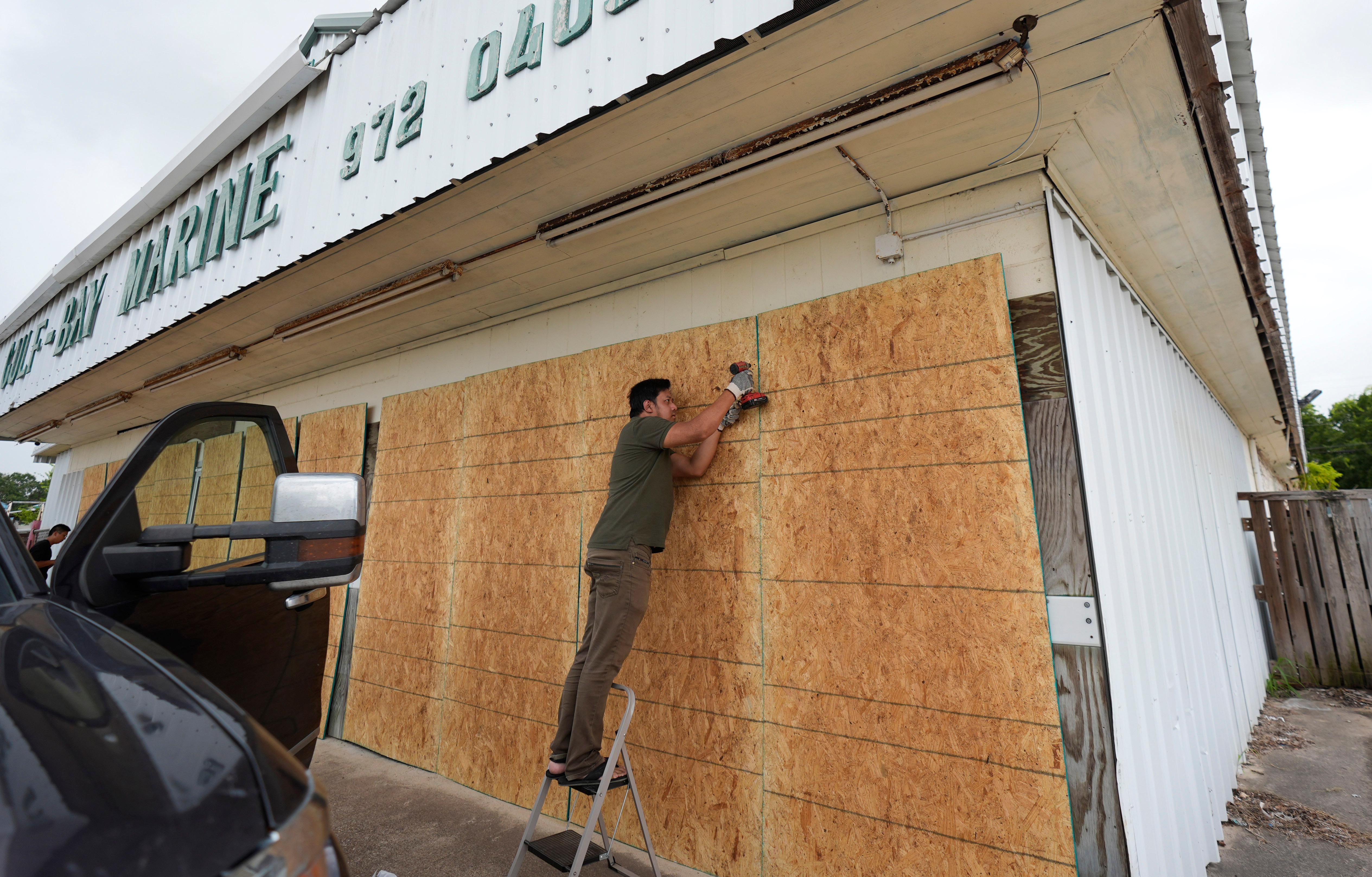 Luan Nguyen boards up windows as he helps prepare for Beryl's arrival, Sunday, July 7, 2024, in Palaciios, Texas. Texas officials are telling coastal residents to expect power outages and flooding as Beryl was forecast to regain hurricane strength before making landfall. Landfall was expected early Monday. (AP Photo/Eric Gay)