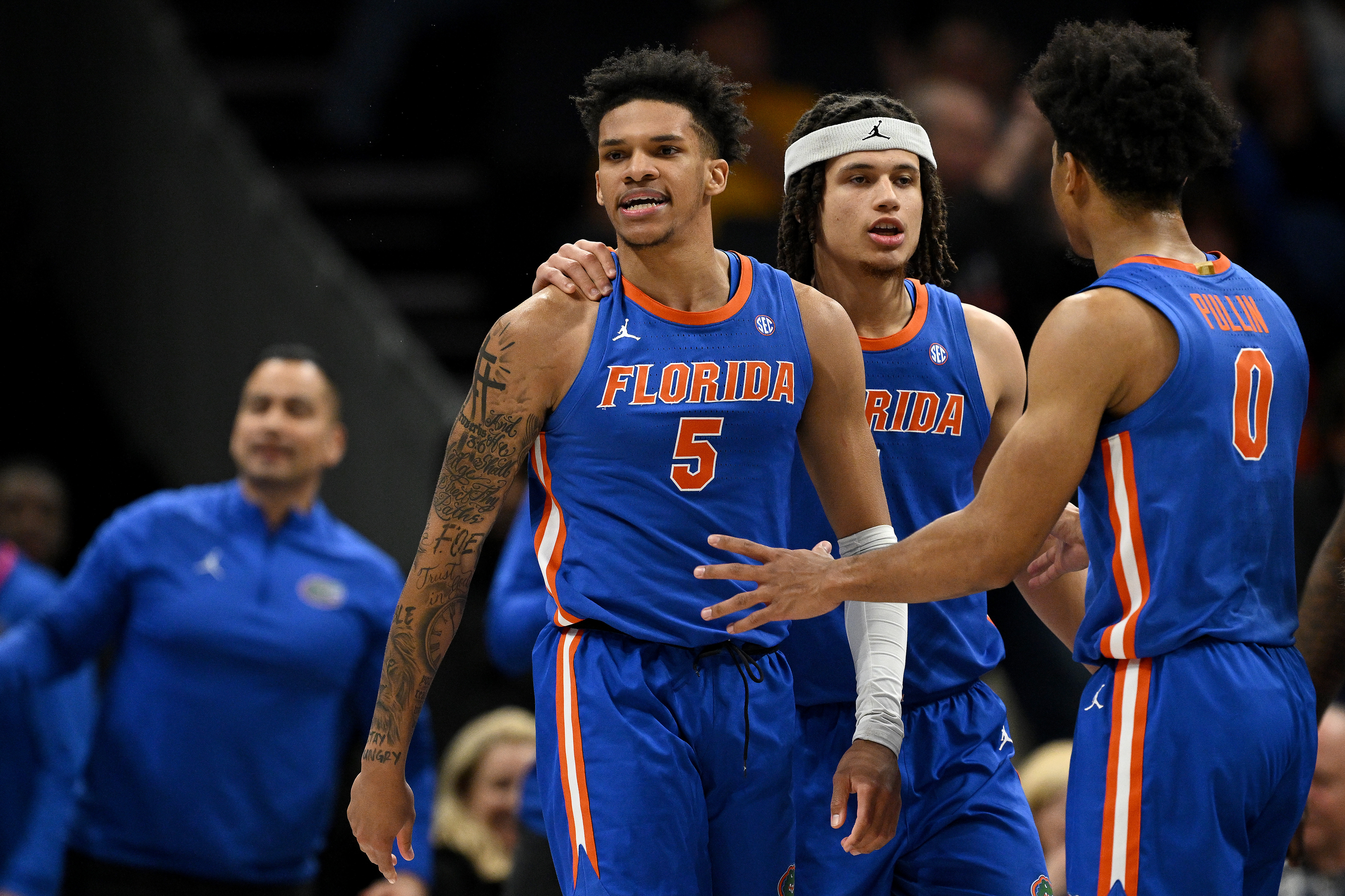 Florida veteran gurads Will Richard (5) and Walter Clayton (1) speak for former point guard Zyon Pullin (0) during the Gators' double-overtime win against Michigan Dec. 19, 2023 in Charlotte, N.C. (Photo by Grant Halverson/Getty Images)