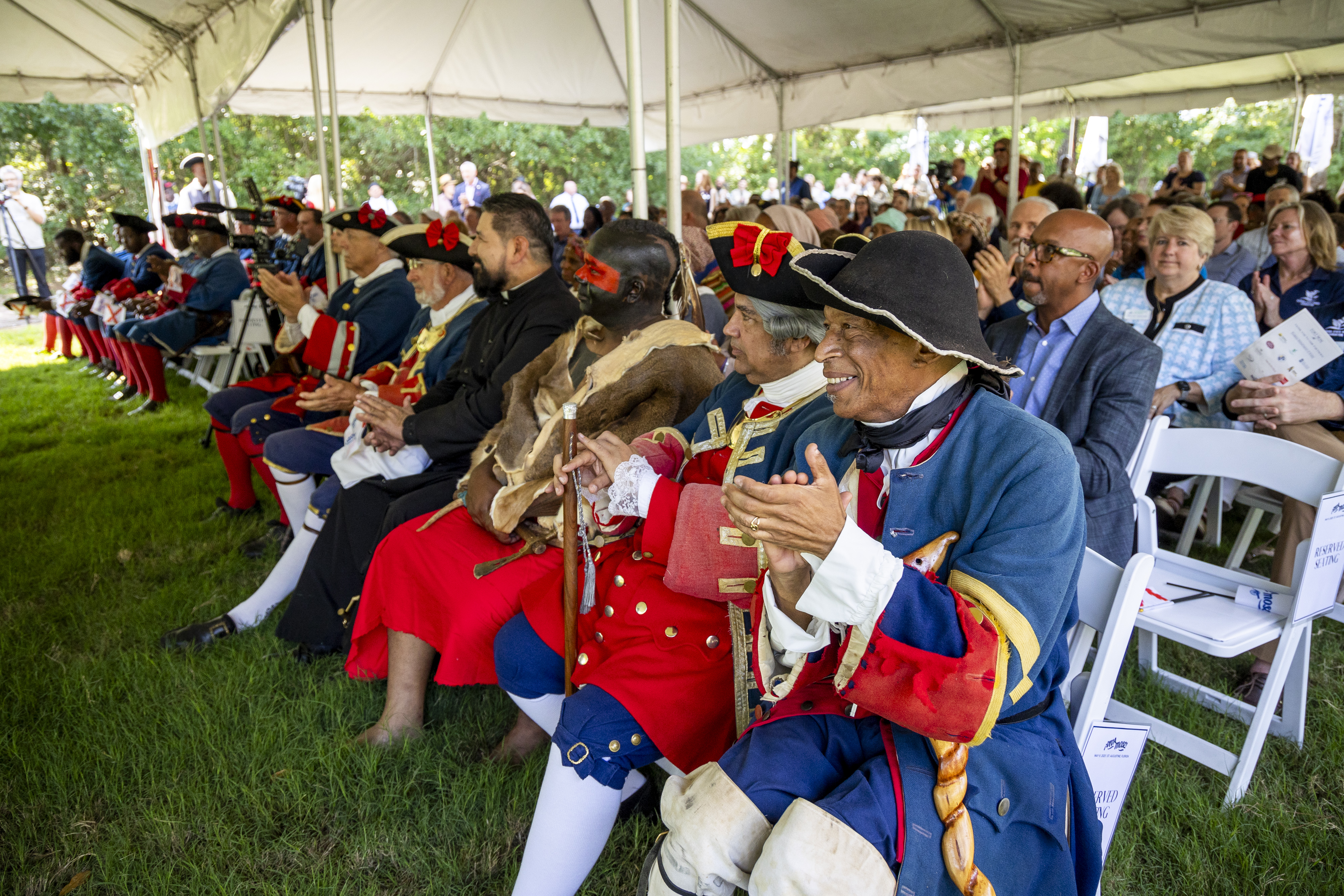 Reenactors applaud during a ribbon-cutting ceremony for a new replica 1738 fort at Fort Mose Historic State Park in St. Augustine on May 9. (Patrick Connolly/Orlando Sentinel)