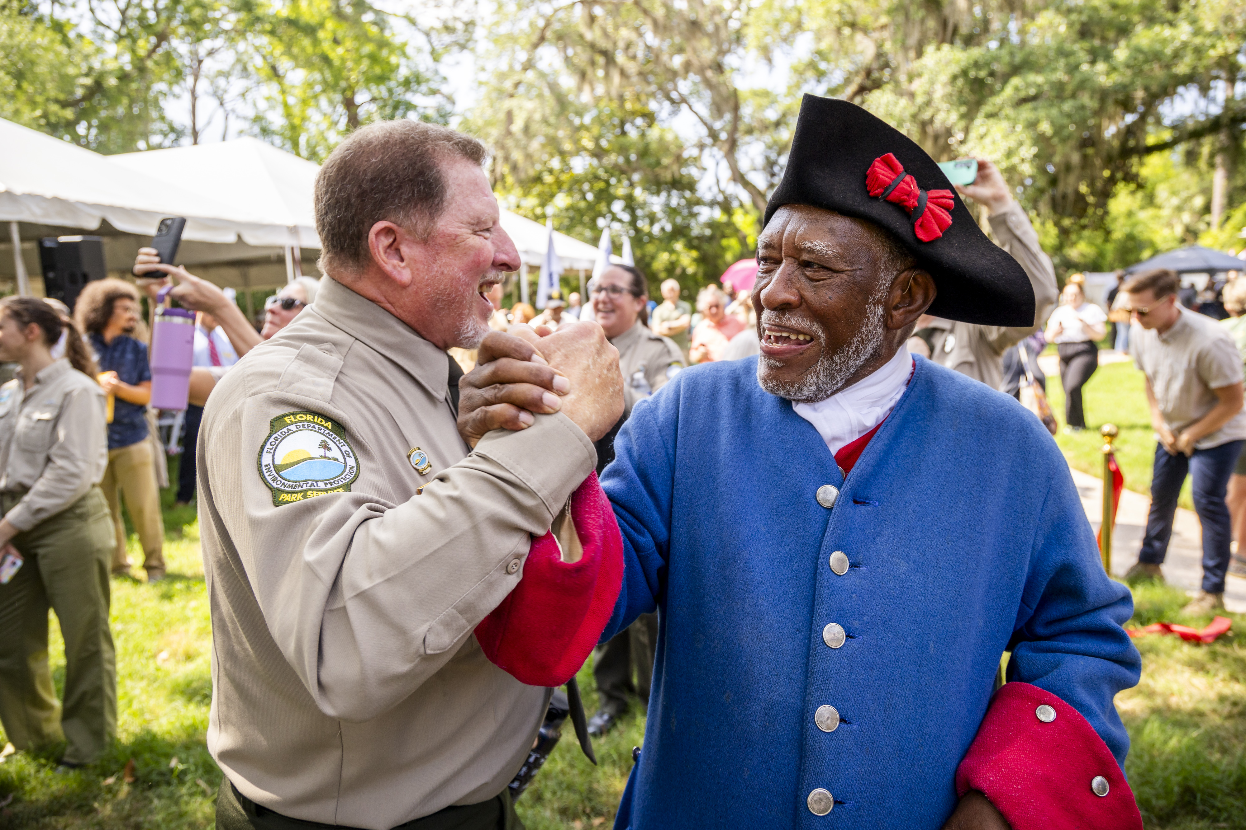 Charles Ellis, right, president of the Fort Mose Historical Society, celebrates with Florida State Parks Director Chuck Hatcher during a ribbon-cutting ceremony for a new replica 1738 fort at Fort Mose Historic State Park in St. Augustine on May 9. (Patrick Connolly/Orlando Sentinel)