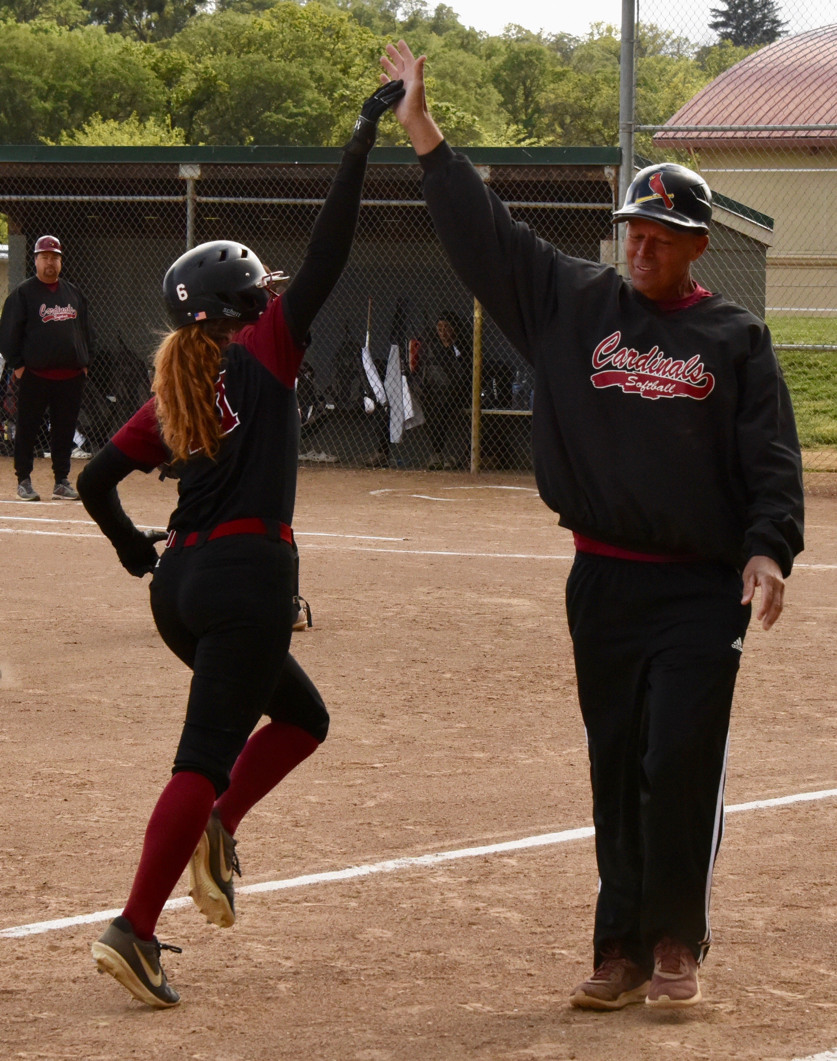Stella Hill and Clear Lake third base coach Phil Psalmonds exchange high-fives.