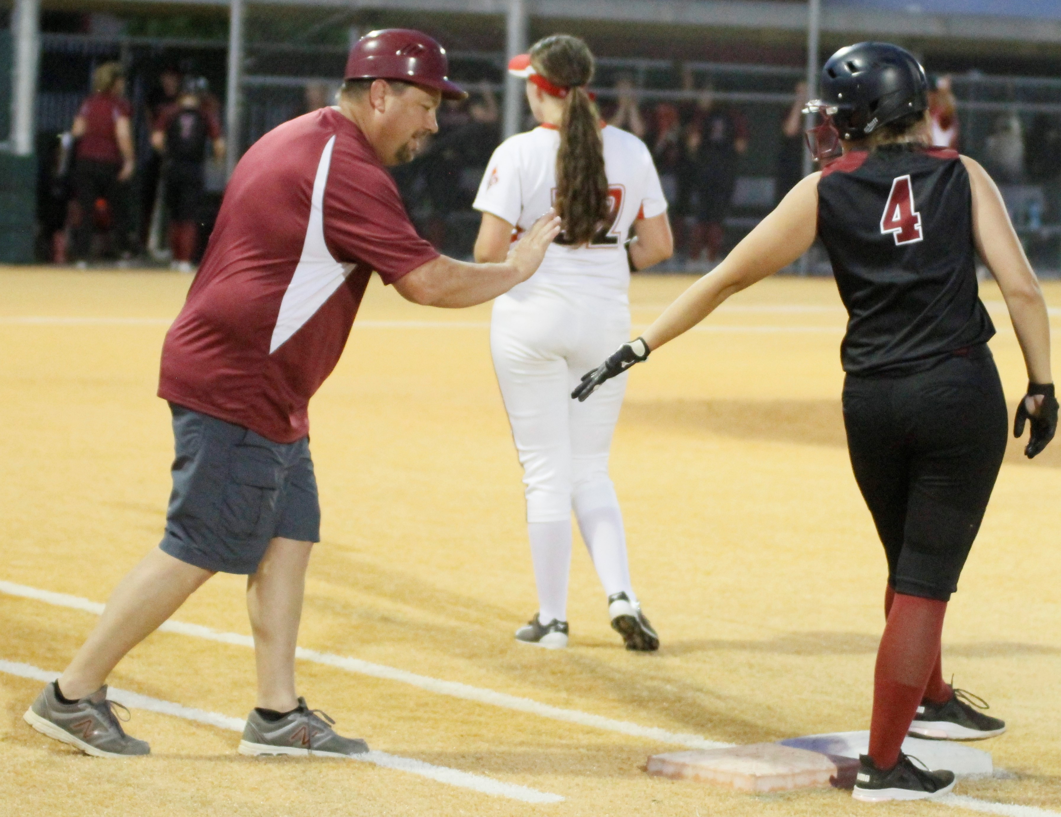 Clear Lake head coach Scott Schaefers congratulates Montana Wells on her two-out single in the top of the seventh.