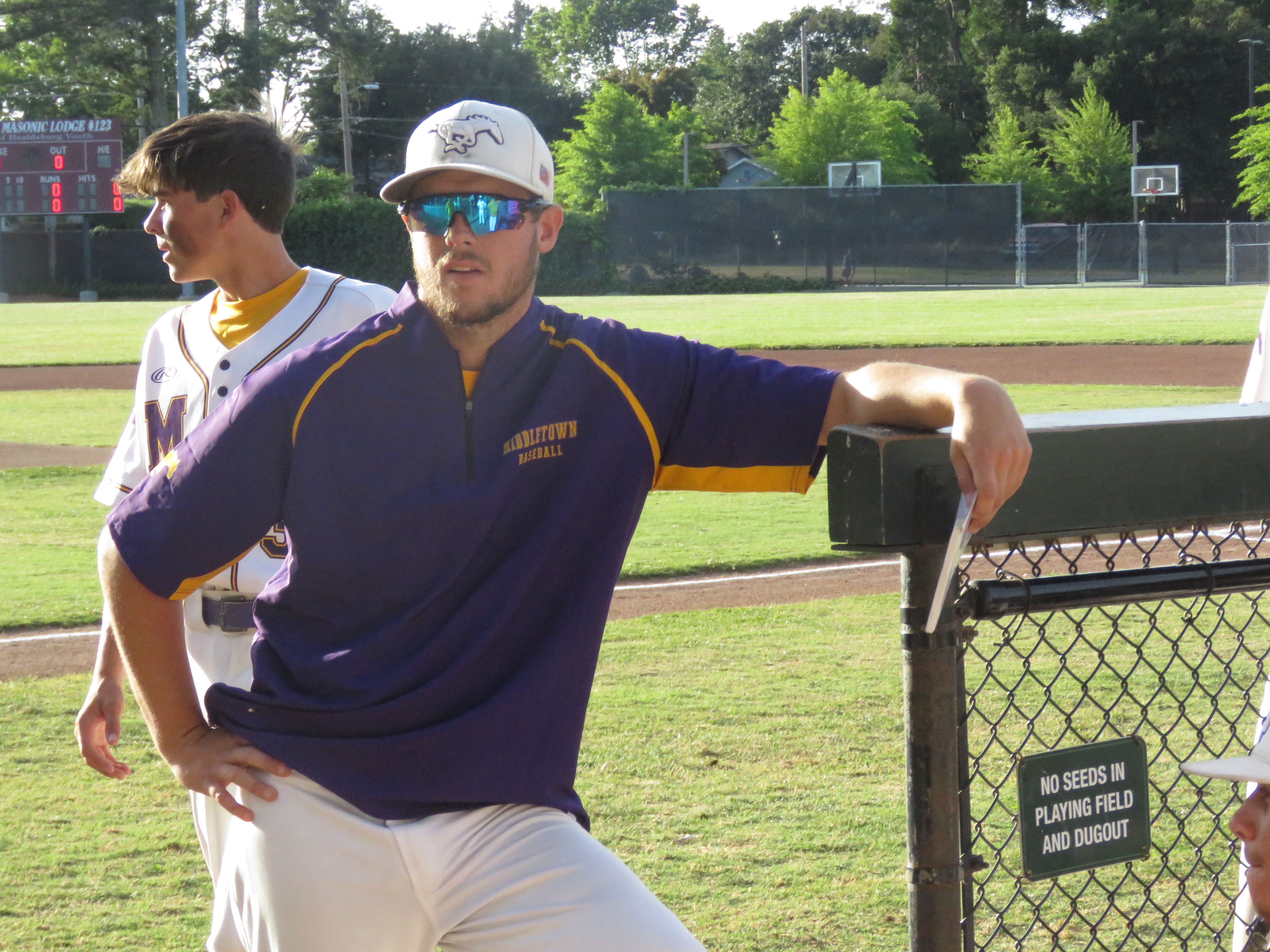 Tyler Holt hangs out with players near the Middletown dugout during warmups Wednesday evening in Healdsburg. Holt guided the Mustangs to a 13-12 record in his first season as head coach, including a 12-2 league mark. (Photos by Brian Sumpter)