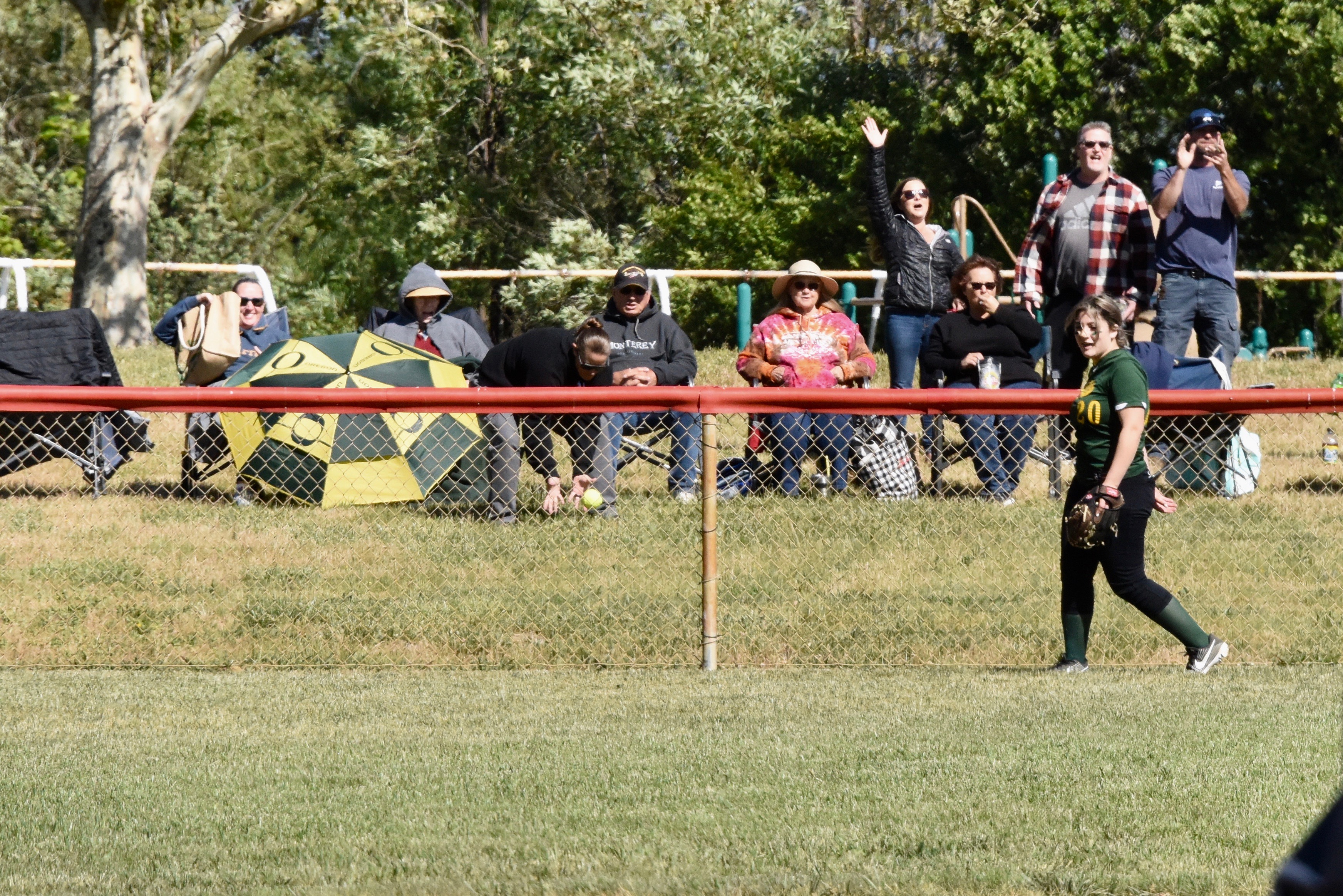 Raina Clifton's home run ball is fielded by former Clear Lake High star catcher Chrissy Jolin behind the fence in left field.