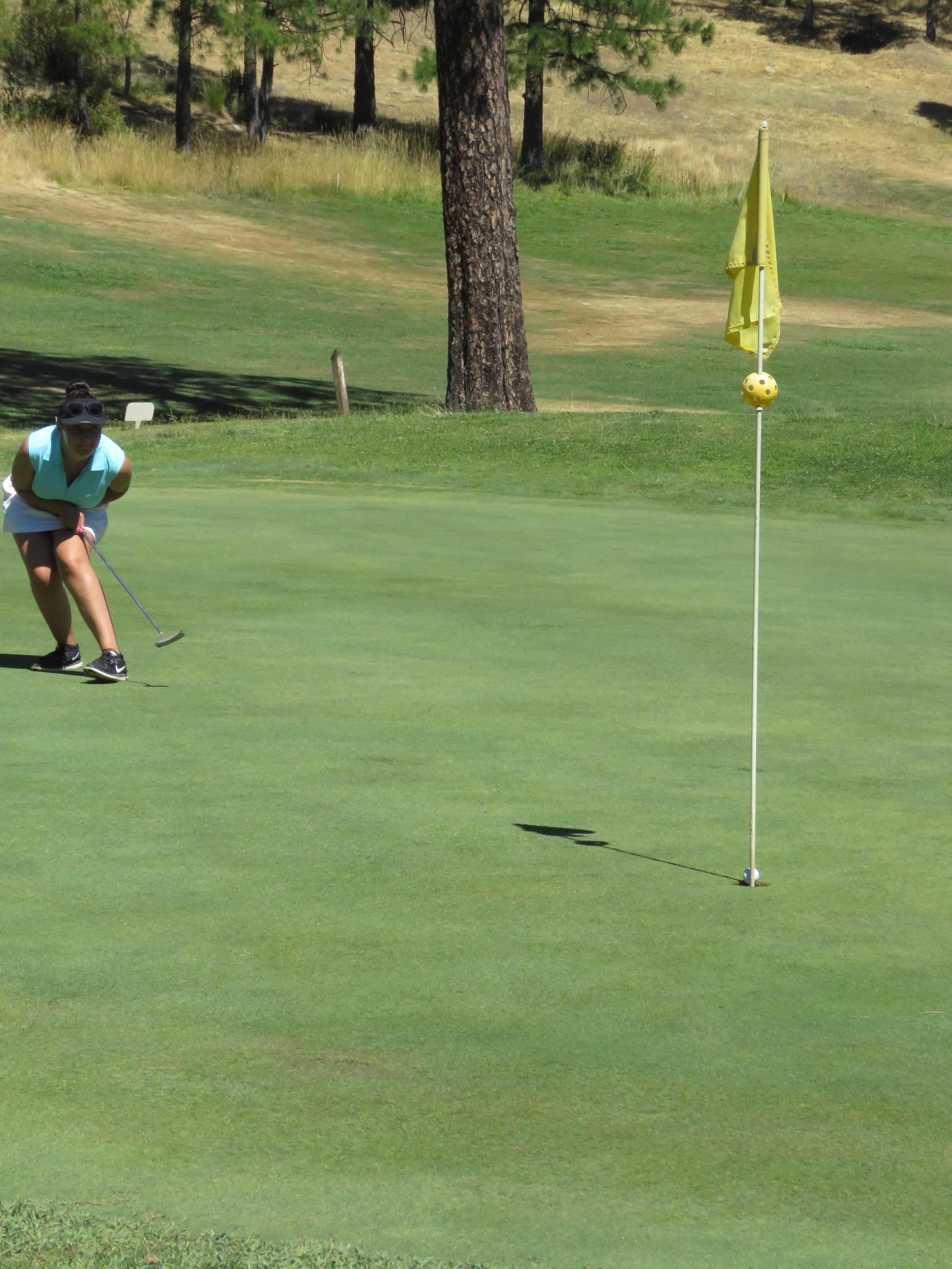 Brooke Hinchcliff crouches down while urging her long putt to drop into the cup, which it did.