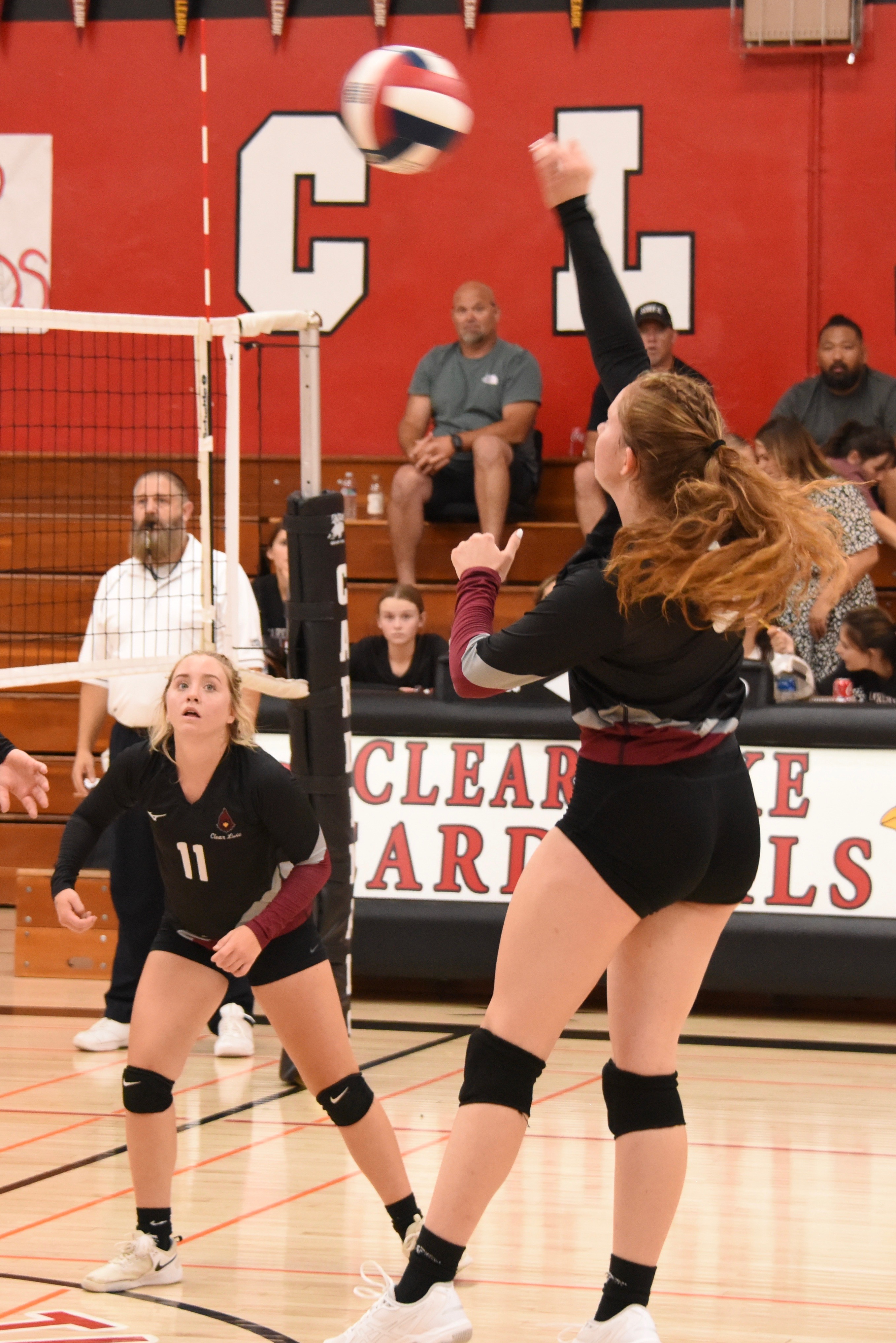 Clear Lake's Stella Hill pounds the ball over the net as teammate Sierra Bruch follows the action. (Photo by Trett Bishop)
