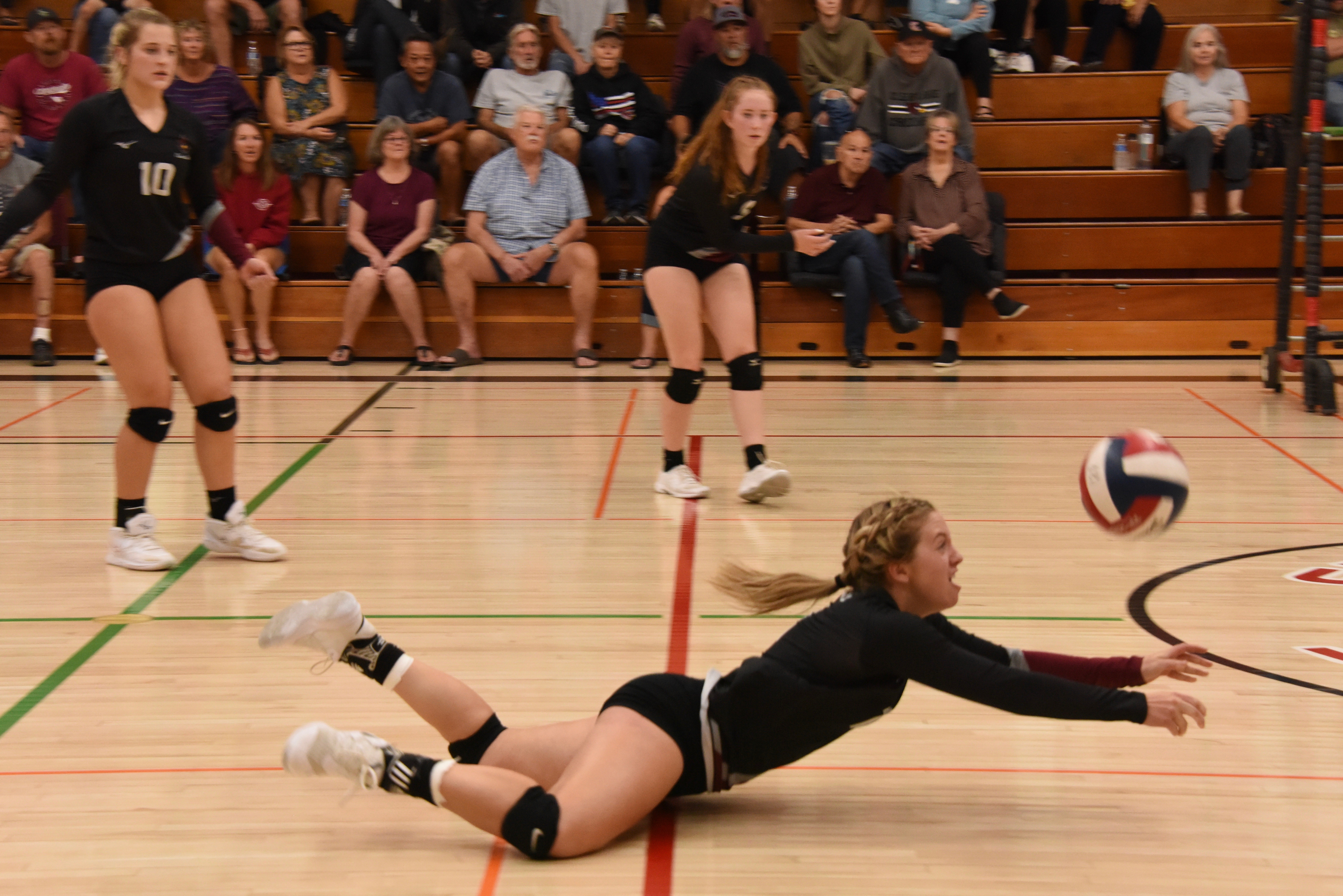 Clear Lake setter Sierra Bruch lays out to dig up the ball as teammates Quincy Paarsch (10) and Stella Hill follow the action Thursday night in Lakeport. (Photos courtesy of Trett Bishop)