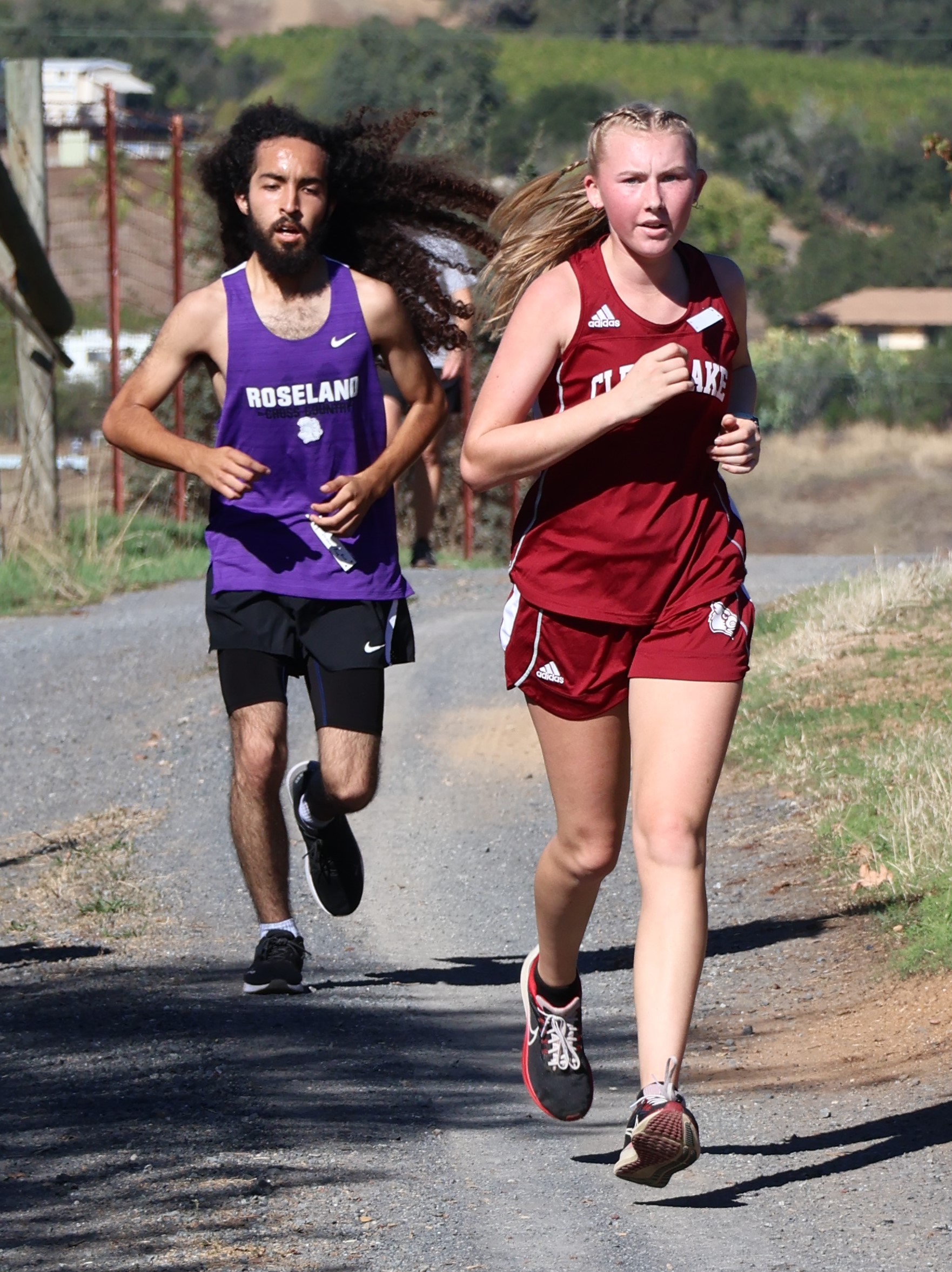 Clear Lake High School's Hannah Garrity leads Roseland University Prep's Juanes Rios during a North Central League I cross country race Wednesday in Asti, which is just south of Cloverdale along Highway 101. Garrity won the 3-mile girls race in 22 minutes, 31 seconds and was third overall. Rios placed third in the boys race in 22:42. (Photos by Brian Sumpter)