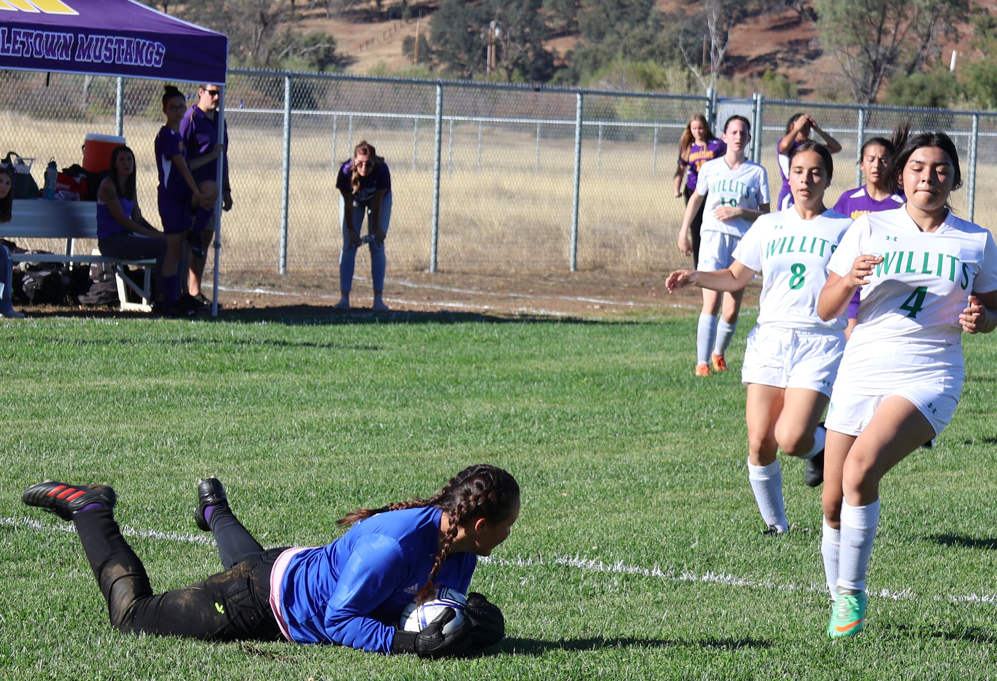 Middletown keeper Krystal Ocken dives on the ball to end a Willits scoring threat with Wolverines star Maia Collins (4) in the vicinity. Collins had four of Willits' six goals. (Photos by Brian Sumpter)