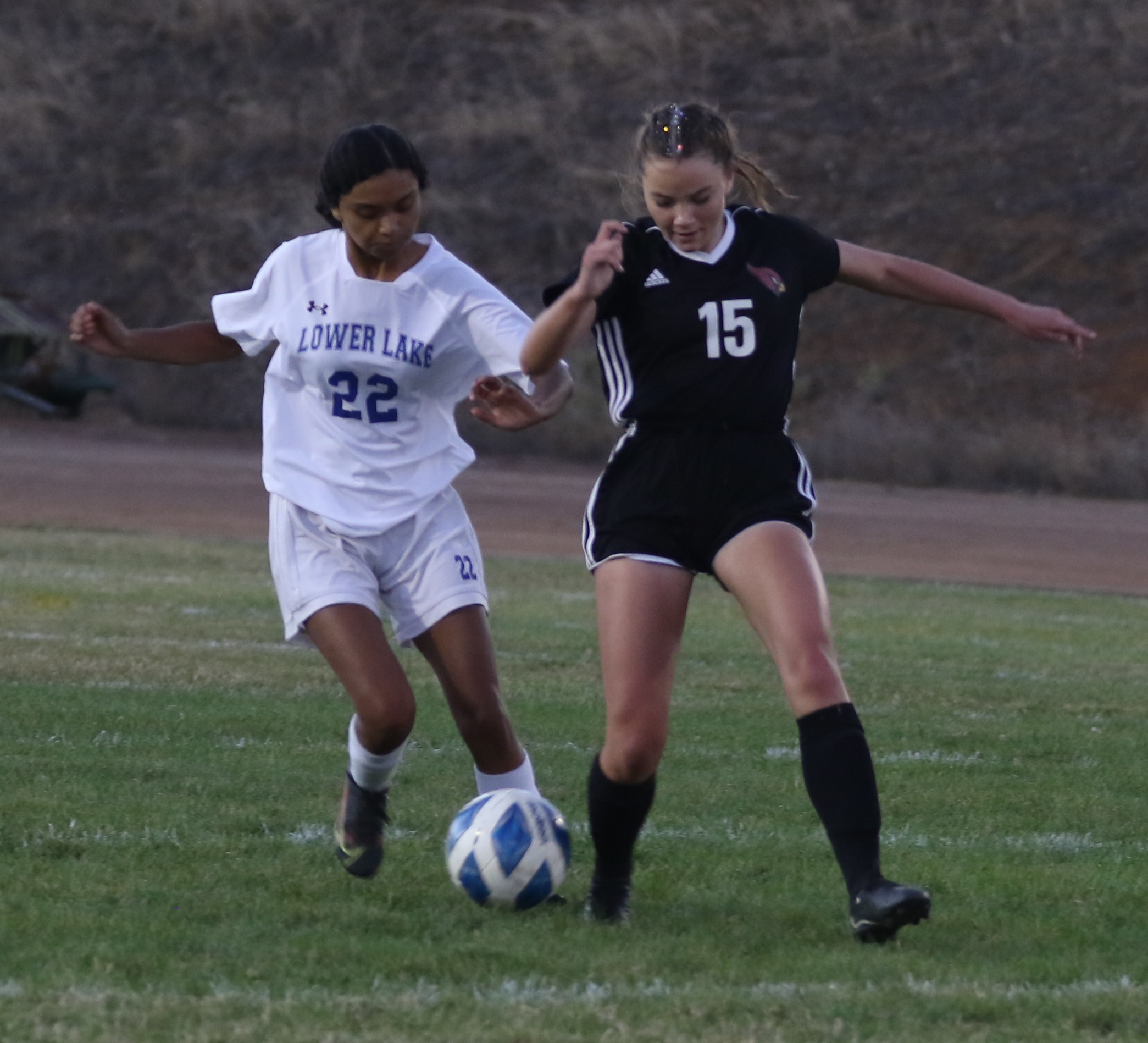 Clear Lake's Ashley Pyorre (right) scored one of the Cardinals' first-half goals in a title-clinching 3-0 win over Lower Lake on Tuesday evening in Lakeport. Defending is Lower Lake's Yusett Guerrero. (Photos by Minenna Photography)