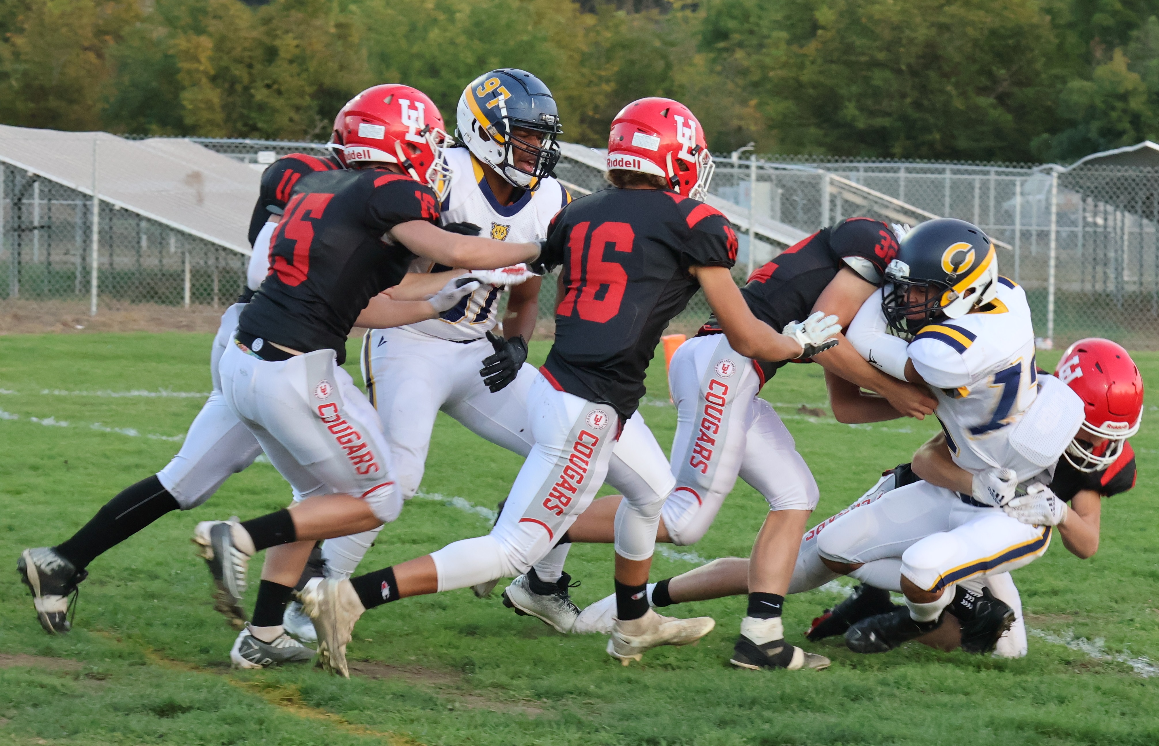 The Upper Lake defense, including Jonathan Barnes (15) and Delaney Allison (16), rallies to the ball in the first half, dropping a Cornerstone Christian player for a loss. (Photos by Brian Sumpter)