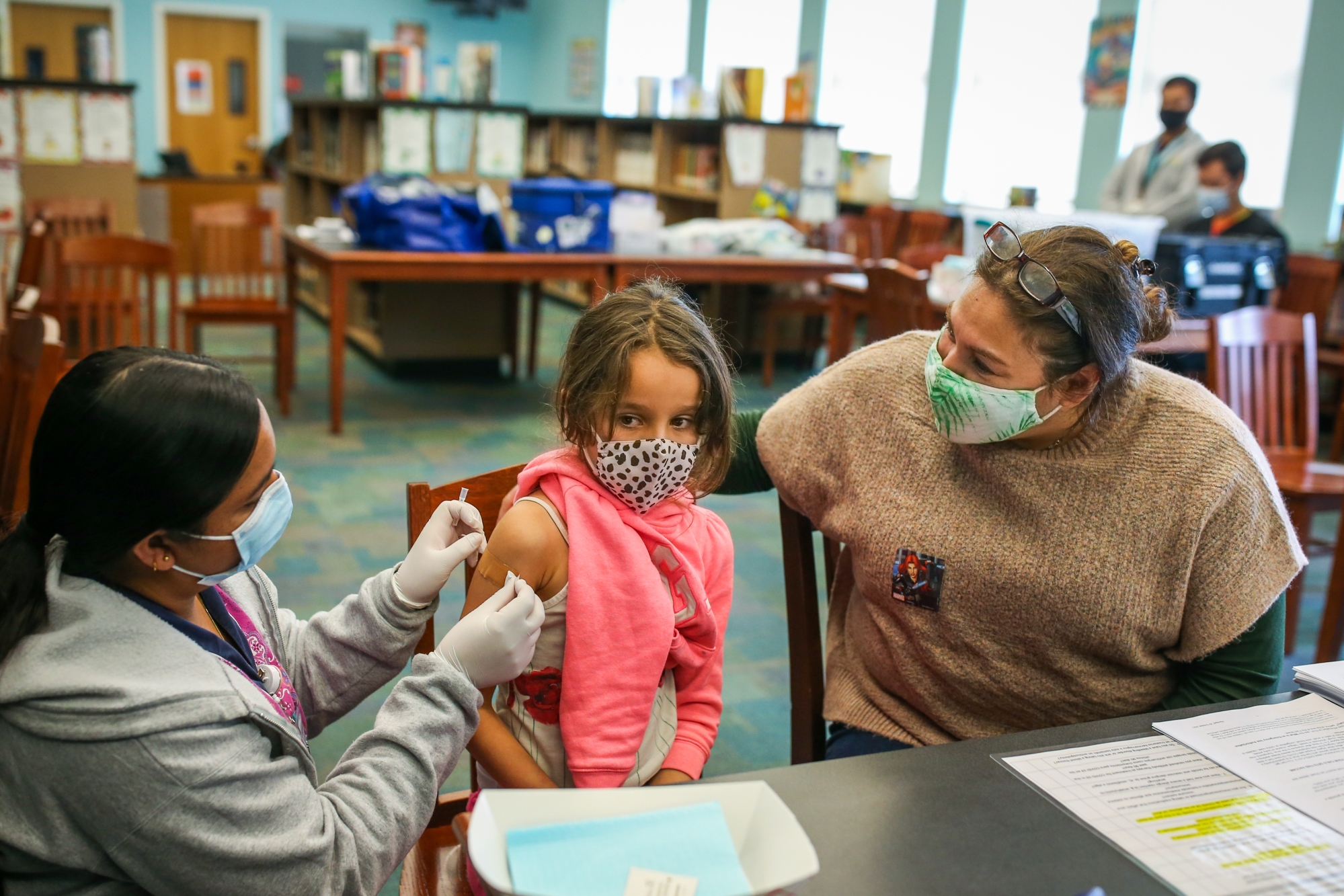 Registered nurse Navneet Chouhan, left, with Contra Costa Health Services (CCHS), puts a bandage on Venus Basaee, 6, after she got the COVID-19 vaccine as her mother Mojgan Deldari looks on during a school-base vaccine clinic at Nystrom Elementary Auditorium in Richmond, Calif., on Tuesday, Nov. 9, 2021. (Photo: Ray Chavez/Bay Area News Group)