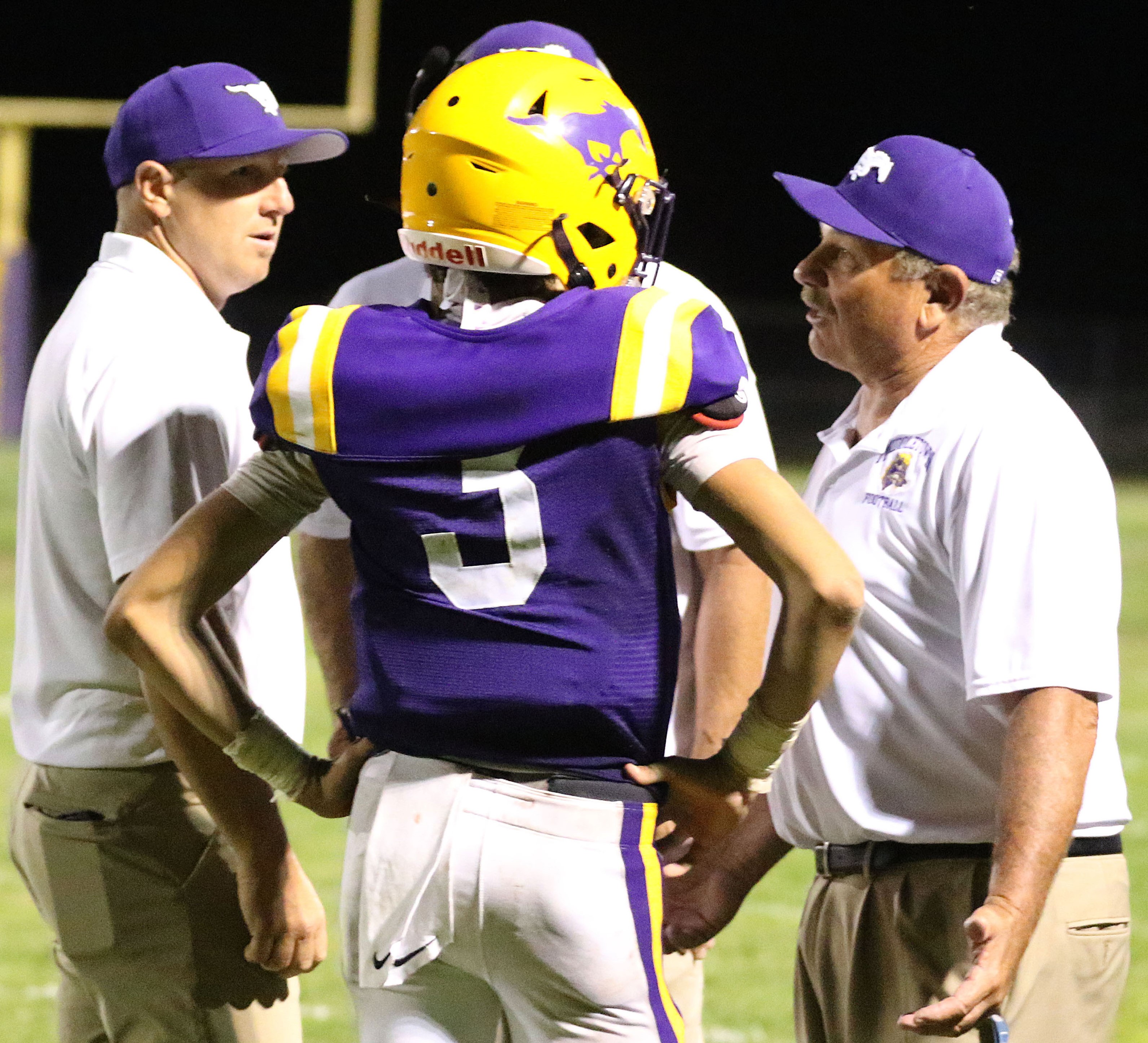 From left, assistant coach Kurtis Woodard, quarterback Hunter Hartzog and head coach Bill Foltmer talk it over during a Willits timeout right before the game-winning two-point conversion in overtime Friday night at Bill Foltmer Field. Middletown changed what proved to be the winning conversion run by running back Brandon Costlow from right to left during the timeout. (Photos by Minenna Photography)