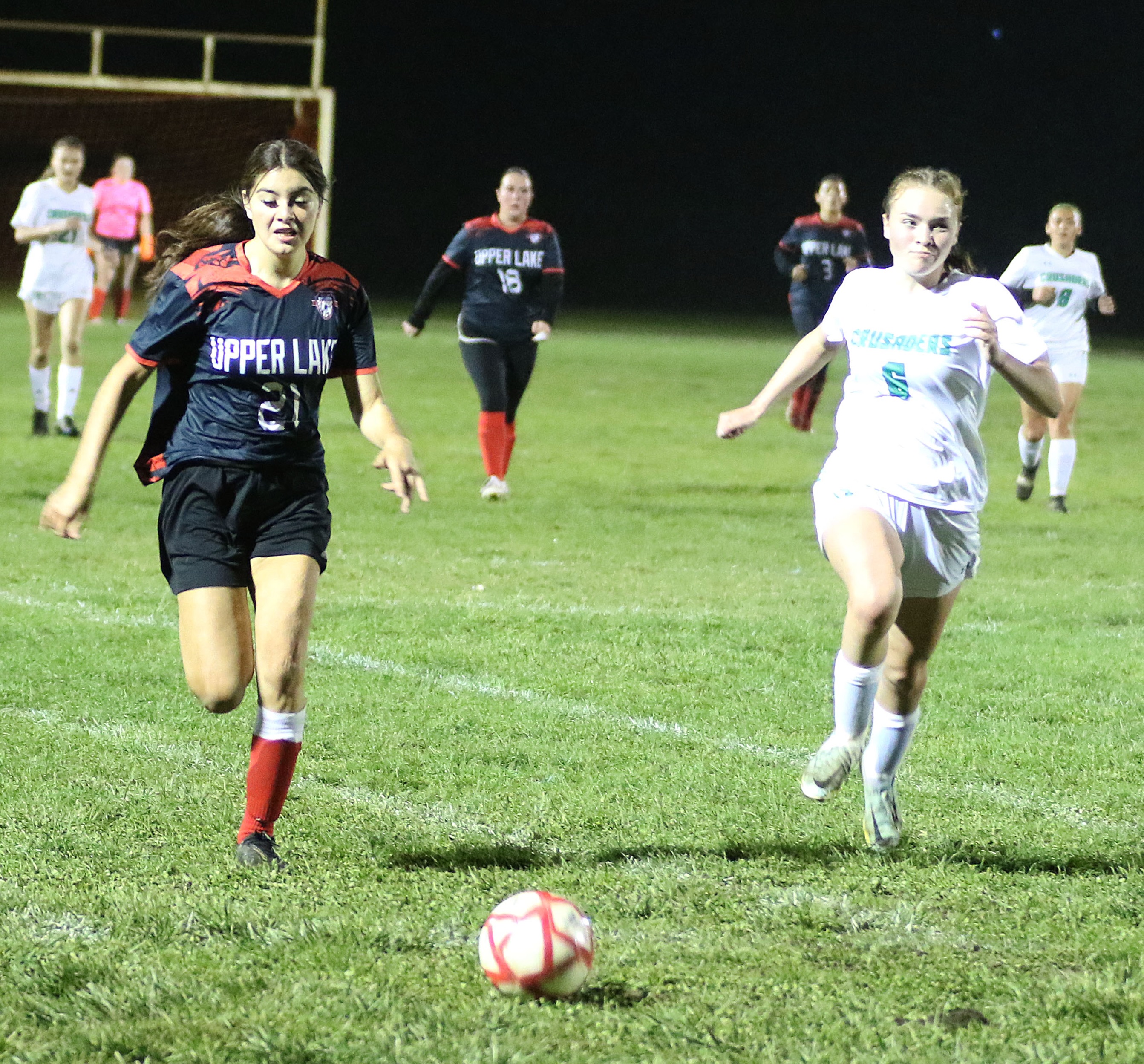 Kat Lopez-Geary (left) races to the ball along with a St. Bernard's play during Friday's action. (Photos by Minenna Photography)
