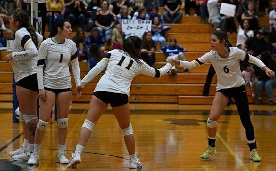 Jacie Clavelle and Zoey White exchange fist bumps during a match as Zoey Pepper looks on. (Courtesy photos)