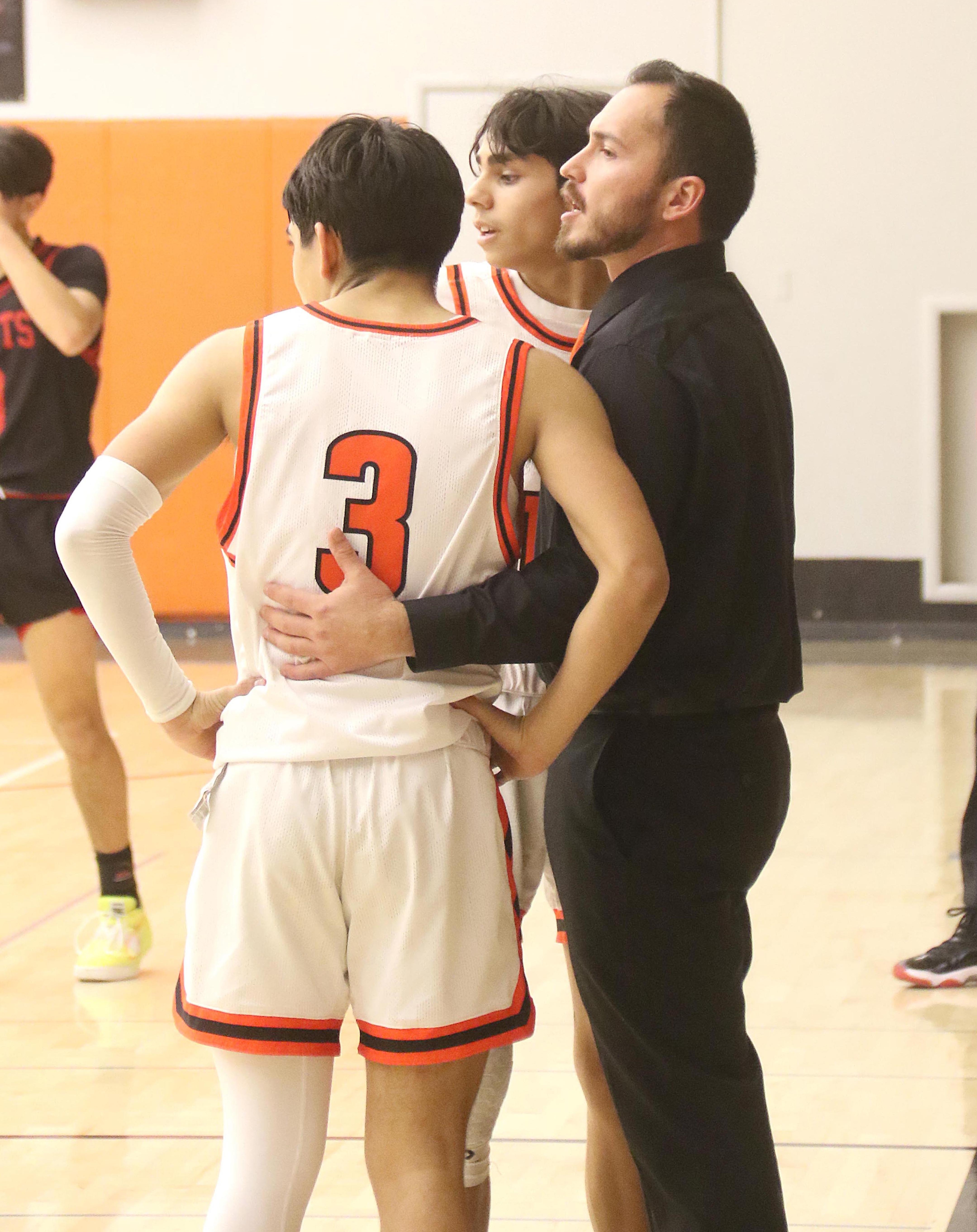 Kelseyville head coach Oscar Lopez consults with Manny Acosta during a break in the action late in the fourth quarter on Monday night. Acosta led the Knights with 20 points, including six 3-pointers, in a 52-48 home win over St. Helena.