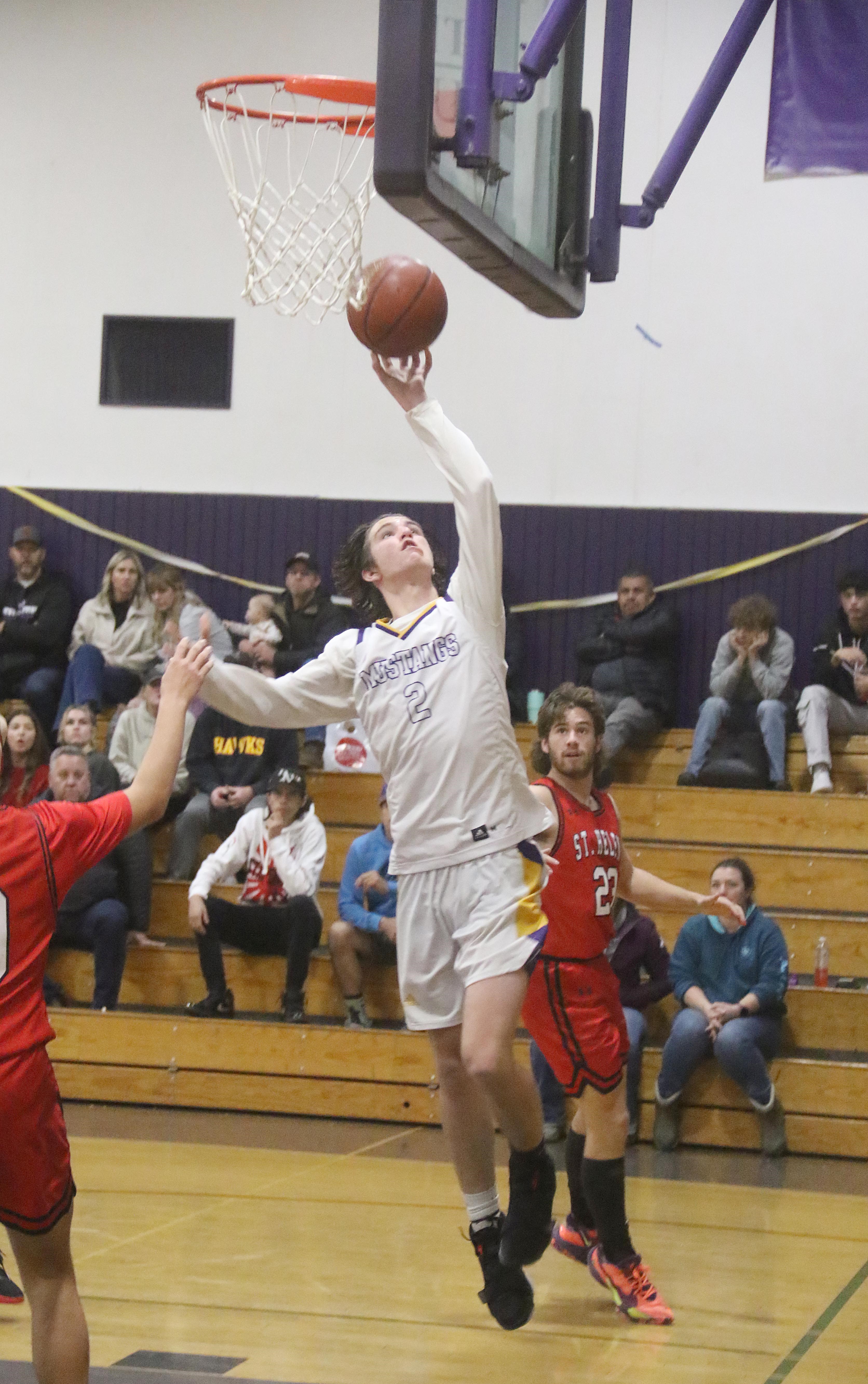 Middletown's Adrian Backus scores two of his nine points against St. Helena. He led the Mustangs with 18 rebounds. (Photos by Minenna Photography)